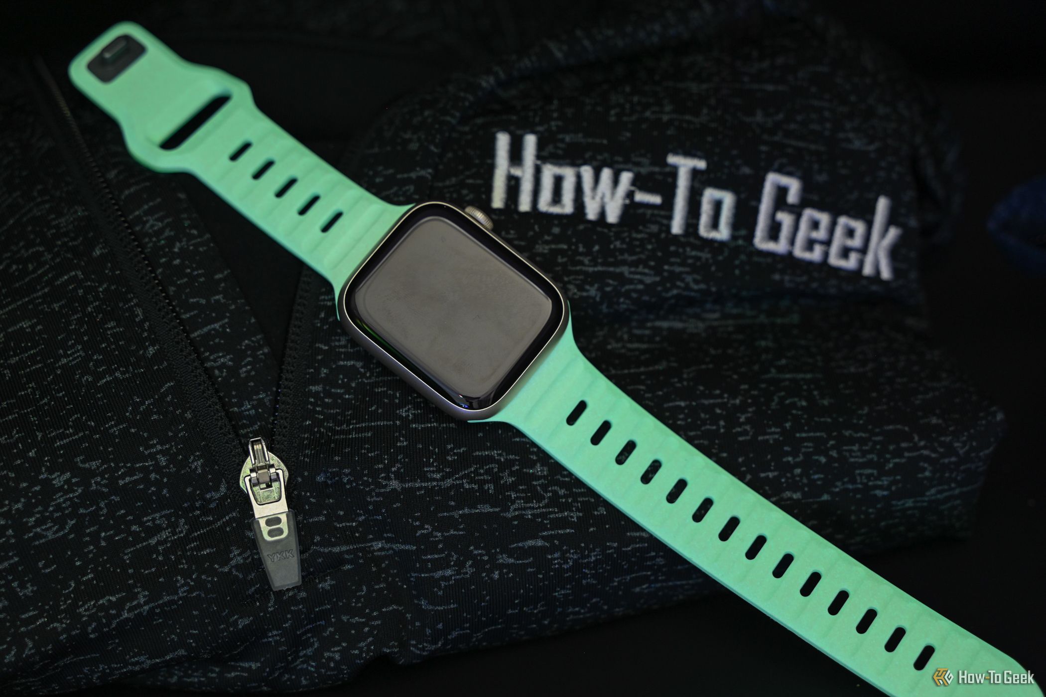 The Glow in the Dark Sport Band laying in the dark glowing green