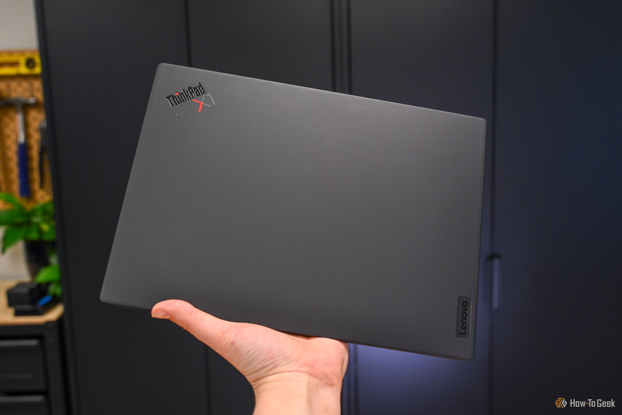 Person holding the closed Lenovo ThinkPad X1 Nano Gen 3.