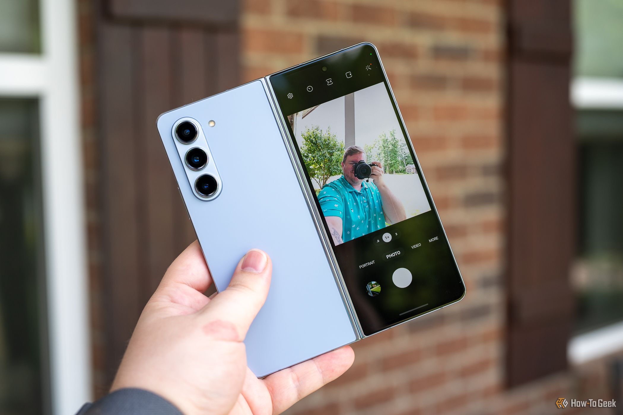 Person taking a selfie using the rear cameras on the Samsung Galaxy Z Fold 5