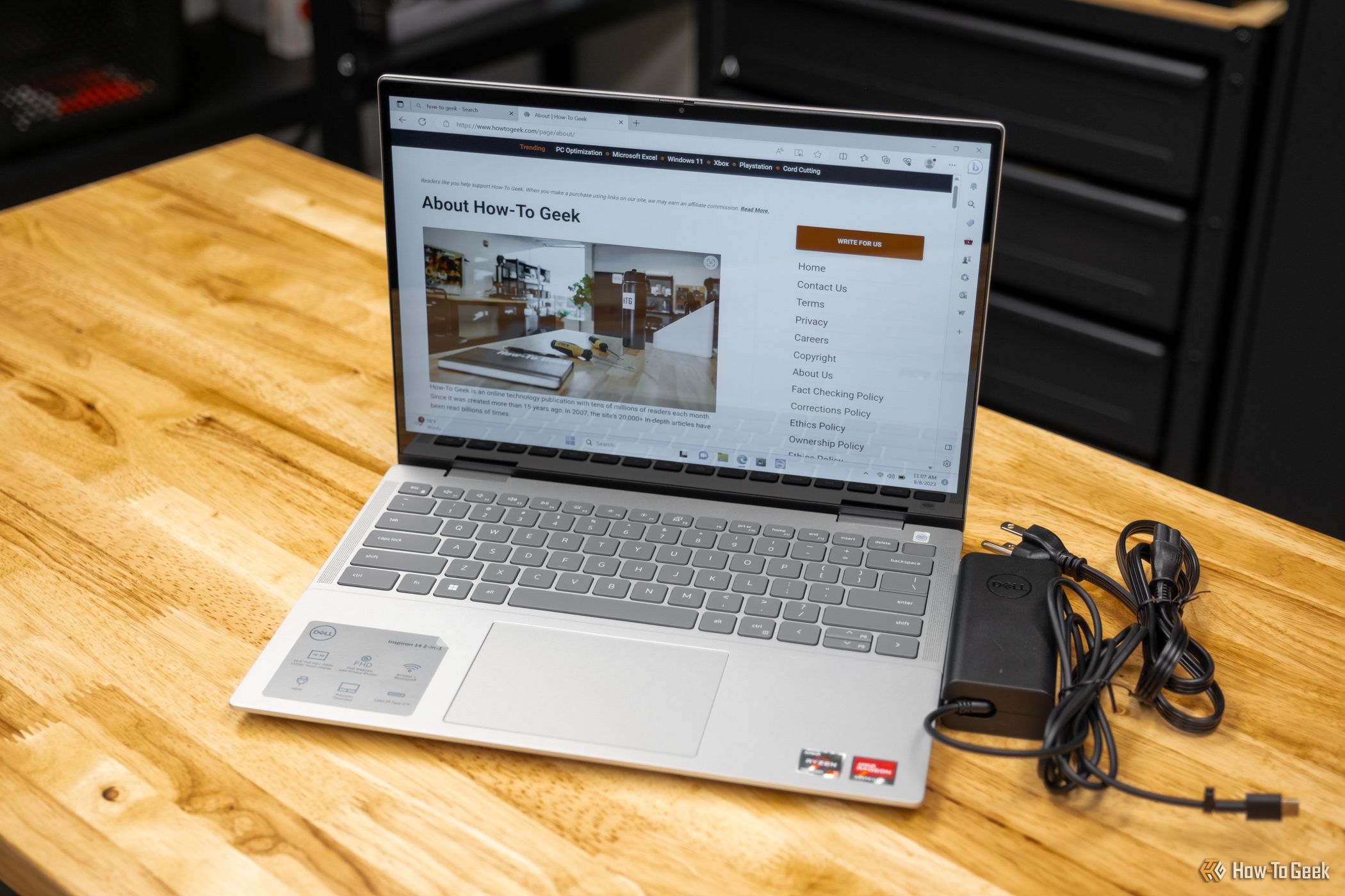 Front view of open Dell Inspiron 14 2-in-1 7435 with charger.