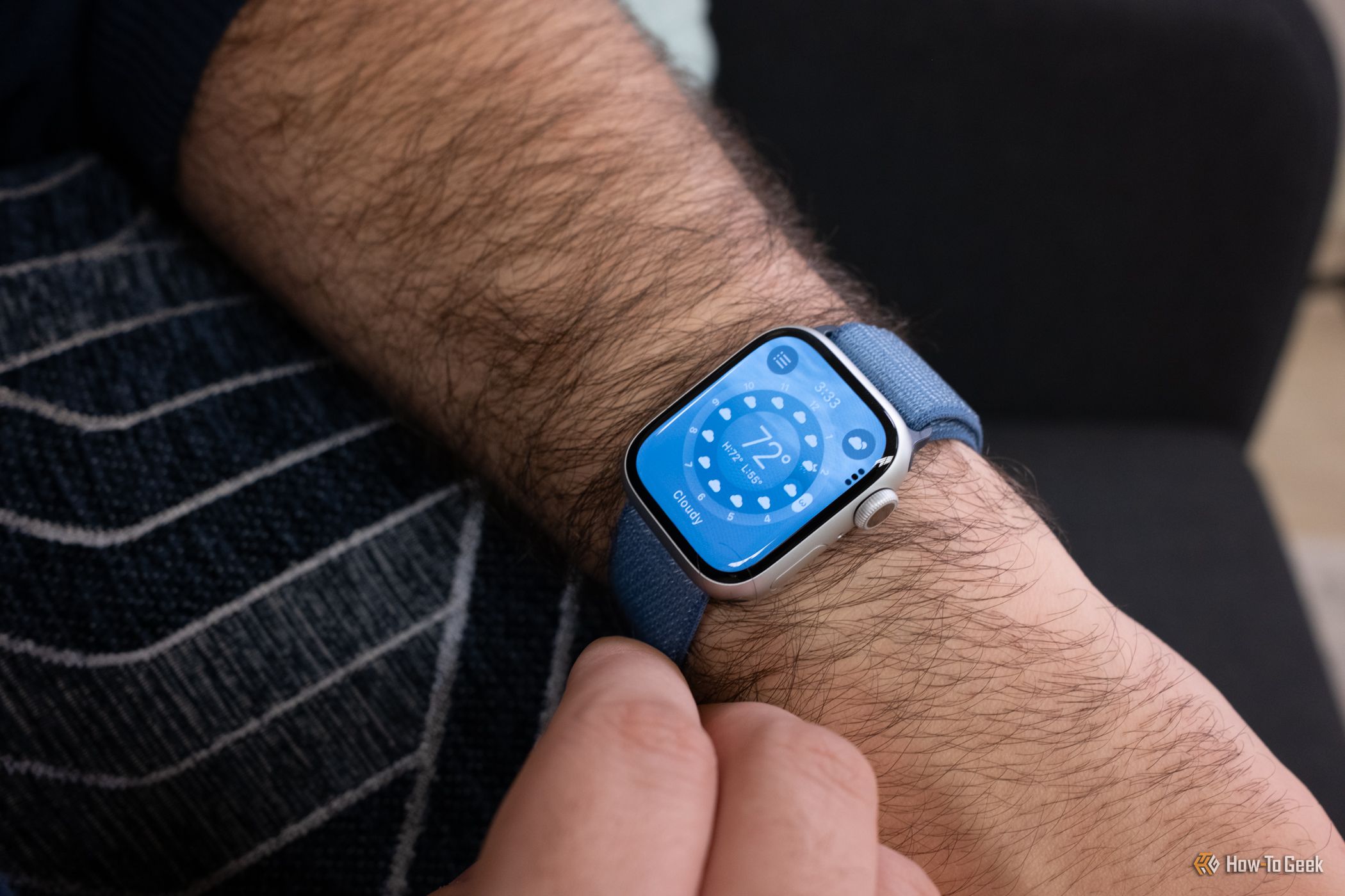 An Apple Watch Series 9 on a person's arm. The display shows the Weather app.