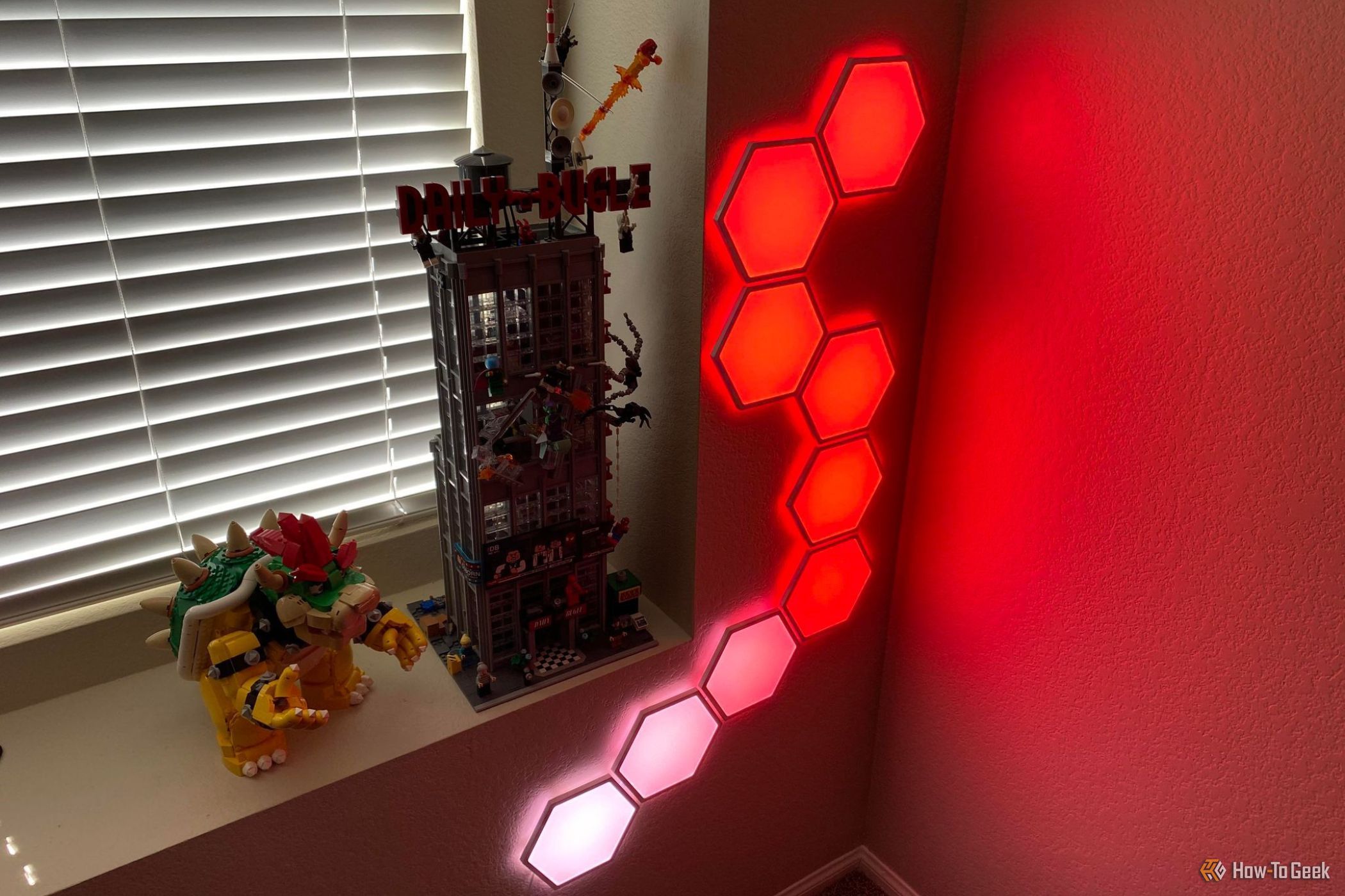 Cync Hexagon Light Kit lit up in red and pink