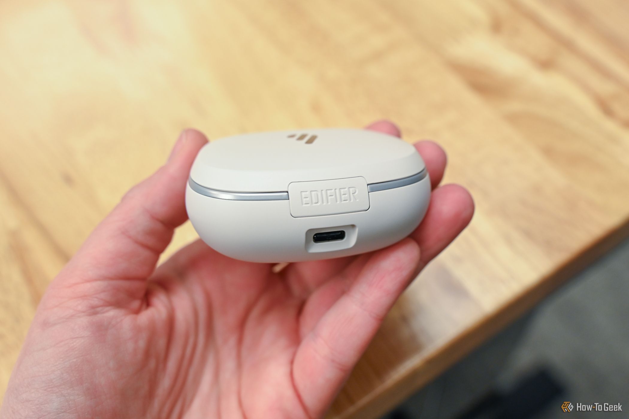 Person holding the Edifier NeoBuds Pro 2 case, showing the USB-C port