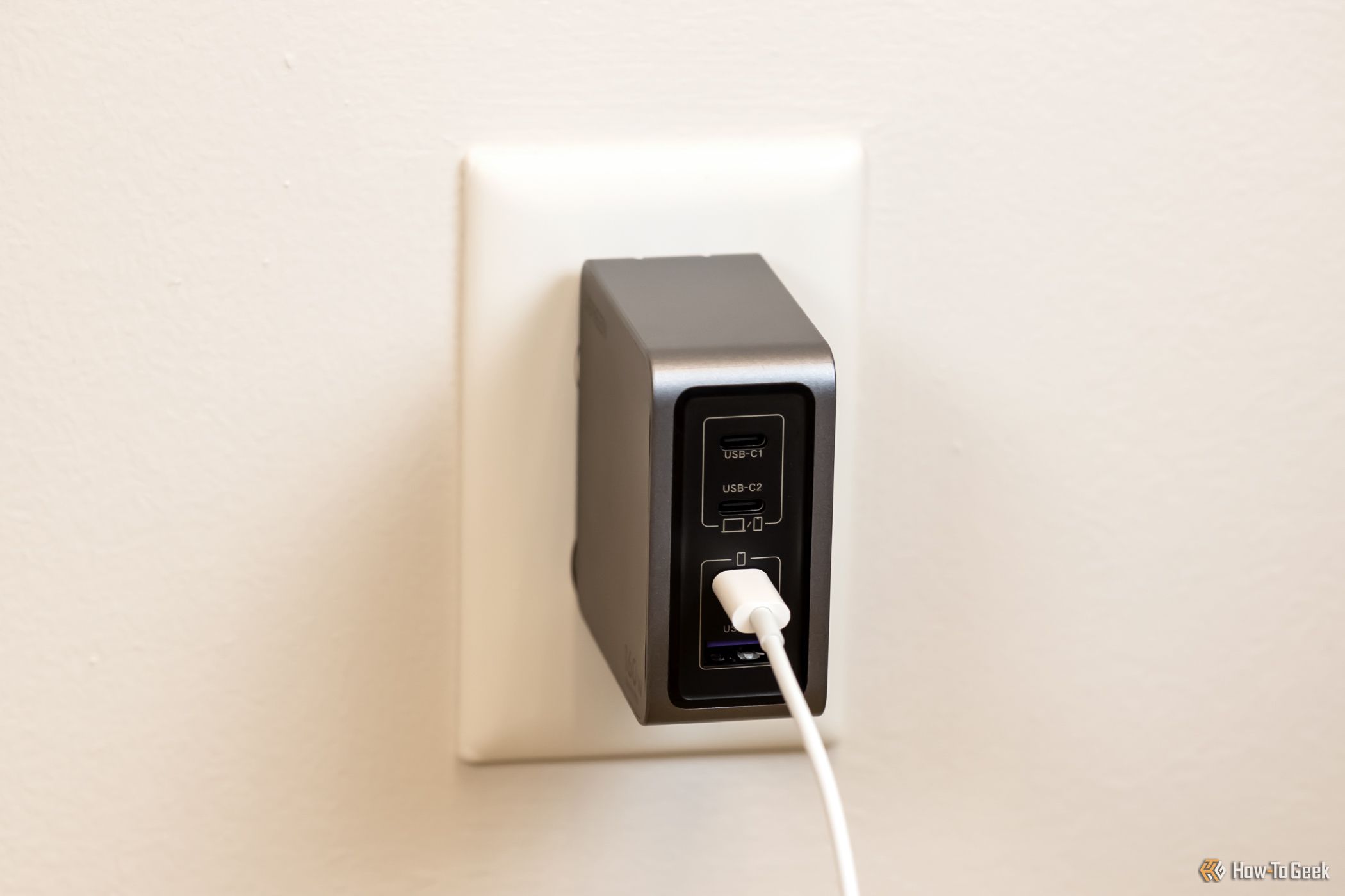 The Ugreen Nexode Pro 160 USB-C Wall Charger plugged into an outlet