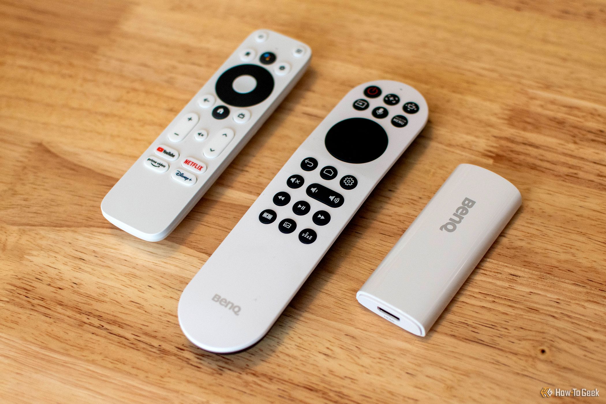 The BenQ X500i Projector's remote control, Android TV dongle, and Android TV remote.