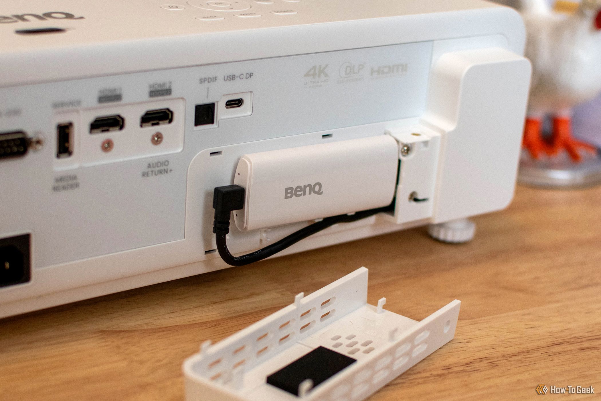 The BenQ X500i Projector's Android TV dongle plugged into video and power. 