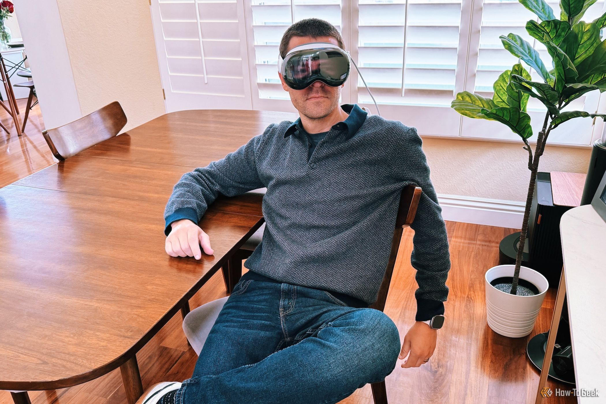 Person wearing an Apple Vision Pro sitting on a chair