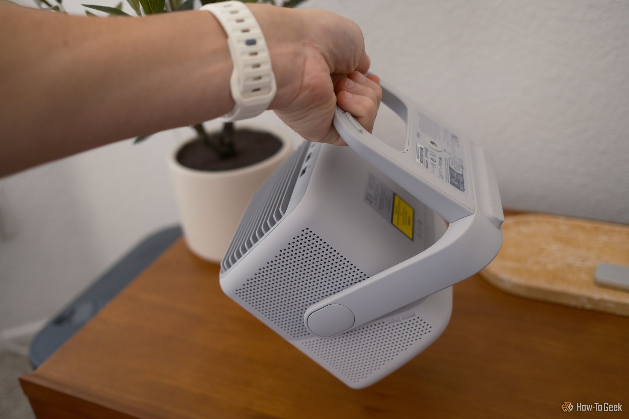 Person holding the JMGO NS1 projector by its stand