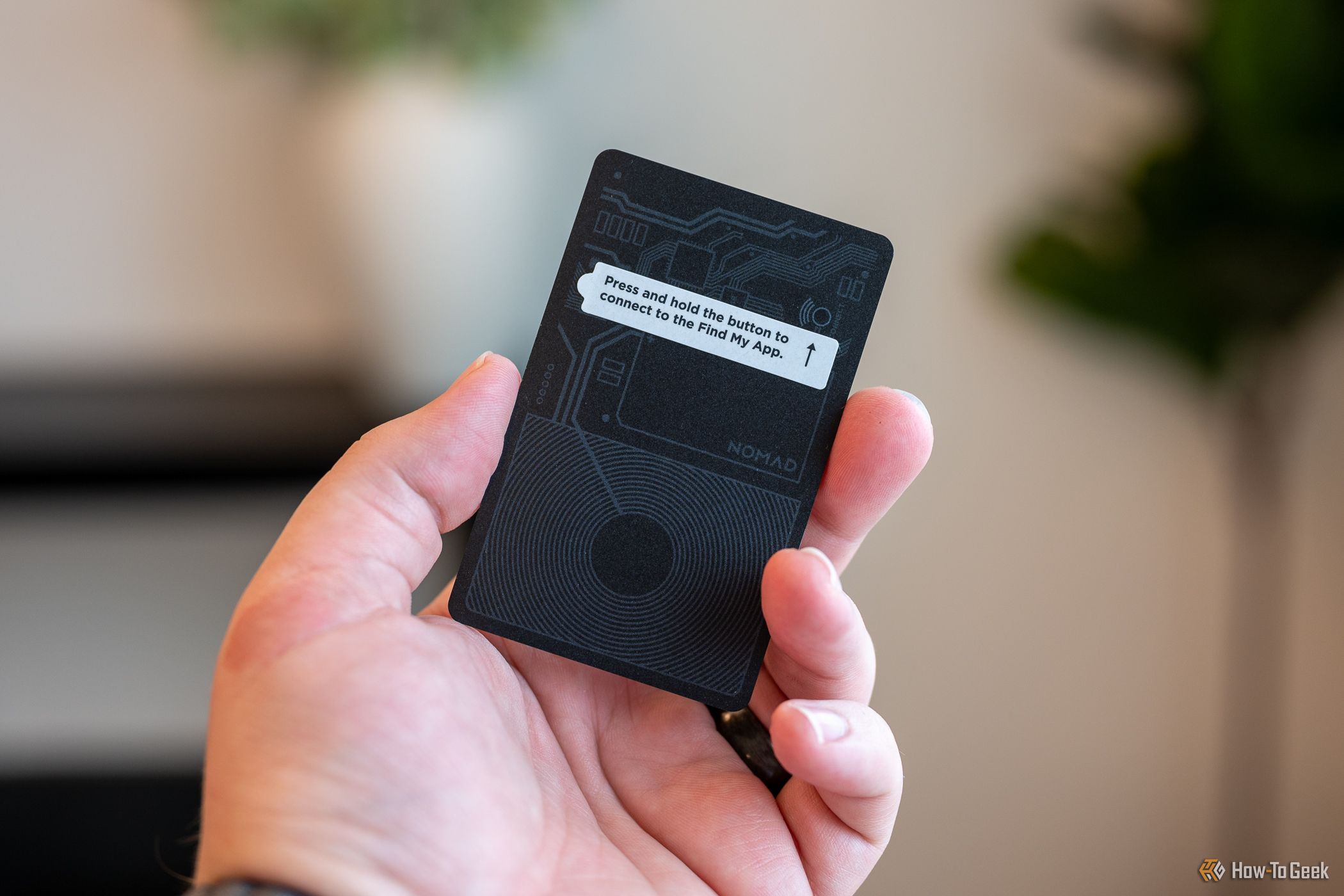 Person holding the Nomad Tracking Card with the instruction sticker