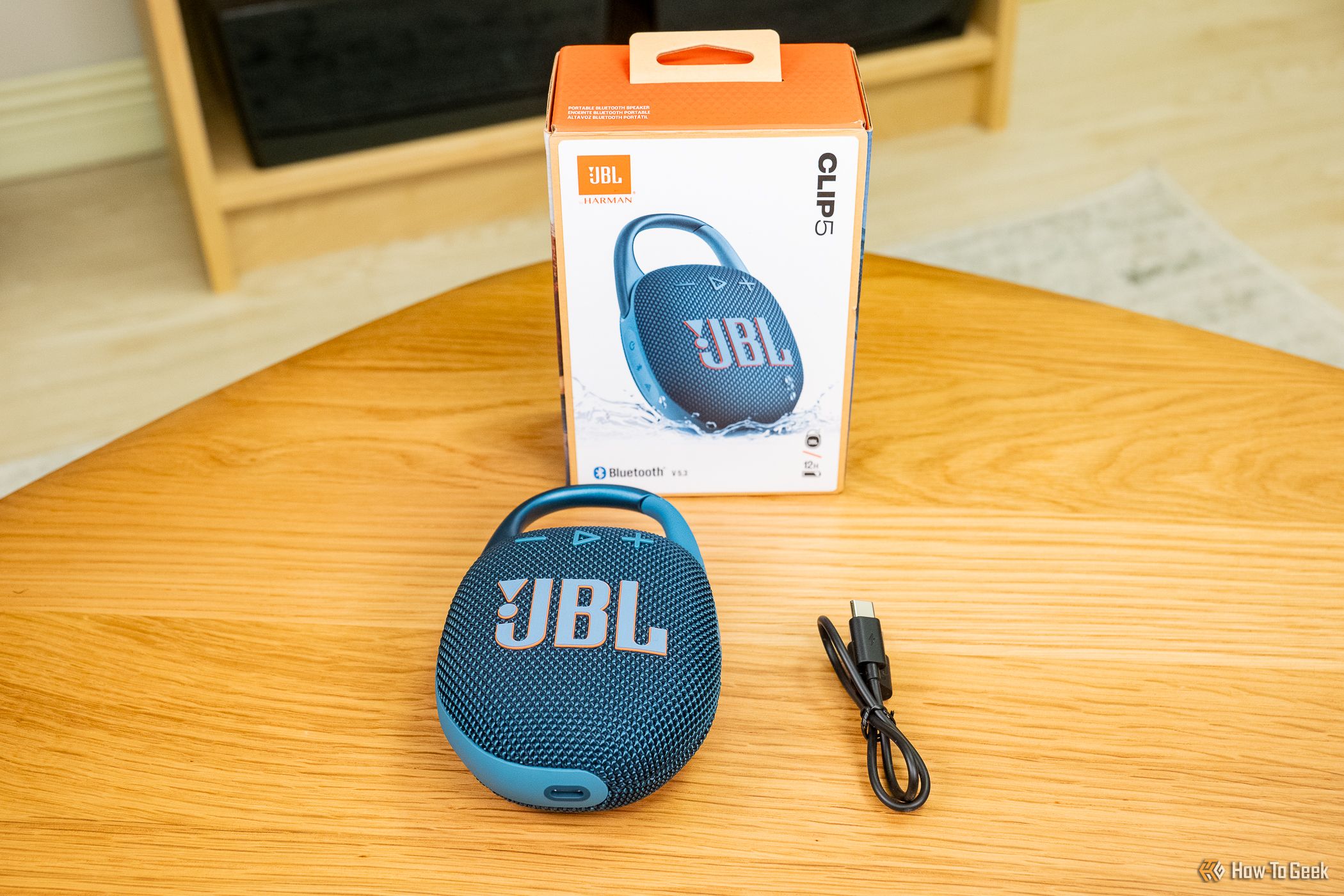 The JBL Clip 5 with its packaging and charging cable.