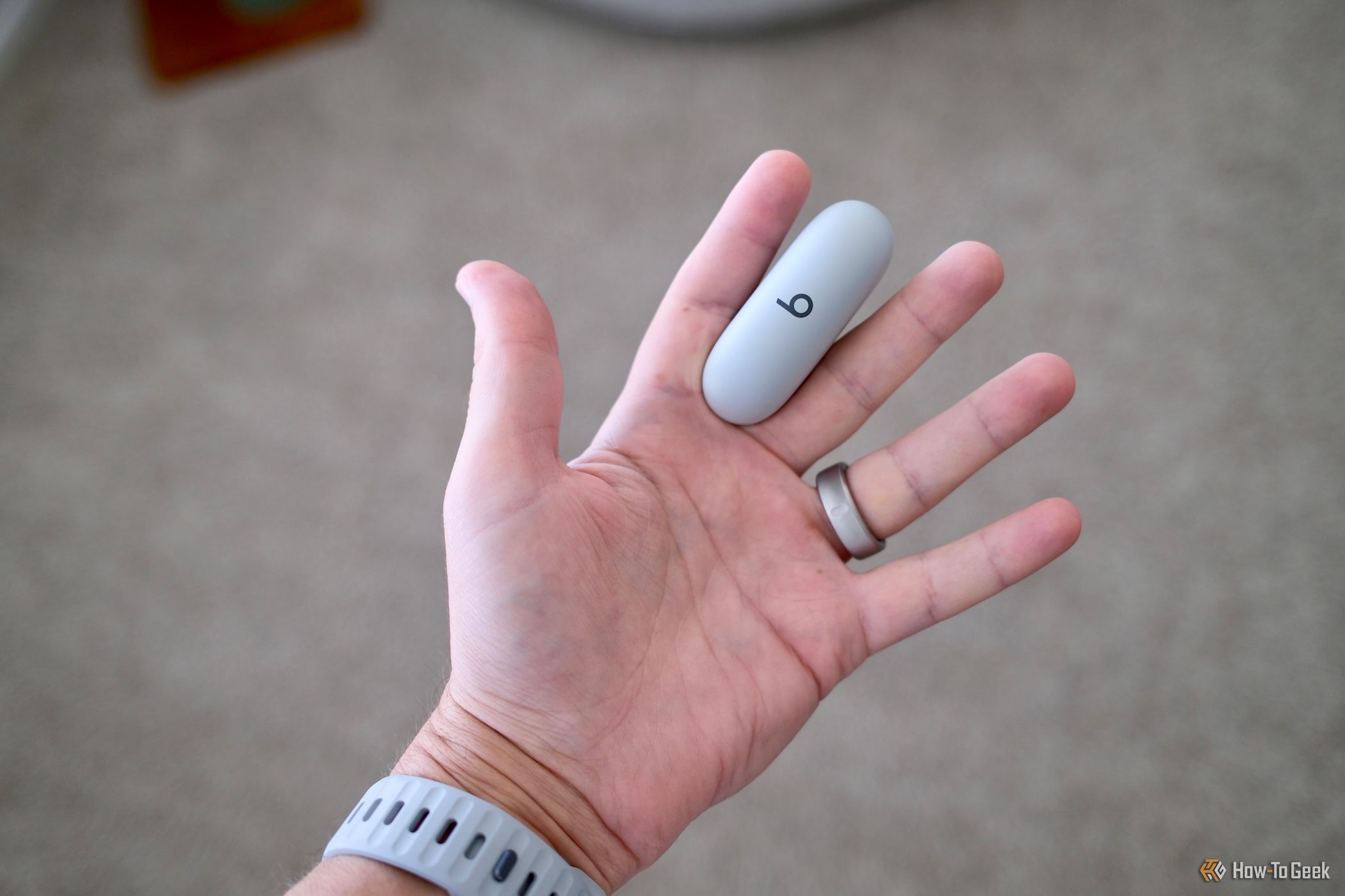 Beats Solo Buds case in between fingers