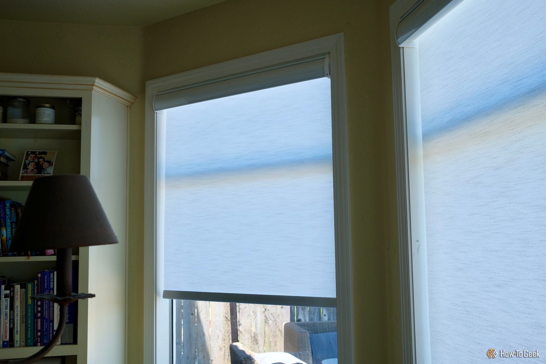 BlindsMagic Smart Motorized Roller Shades halfway closed on a window