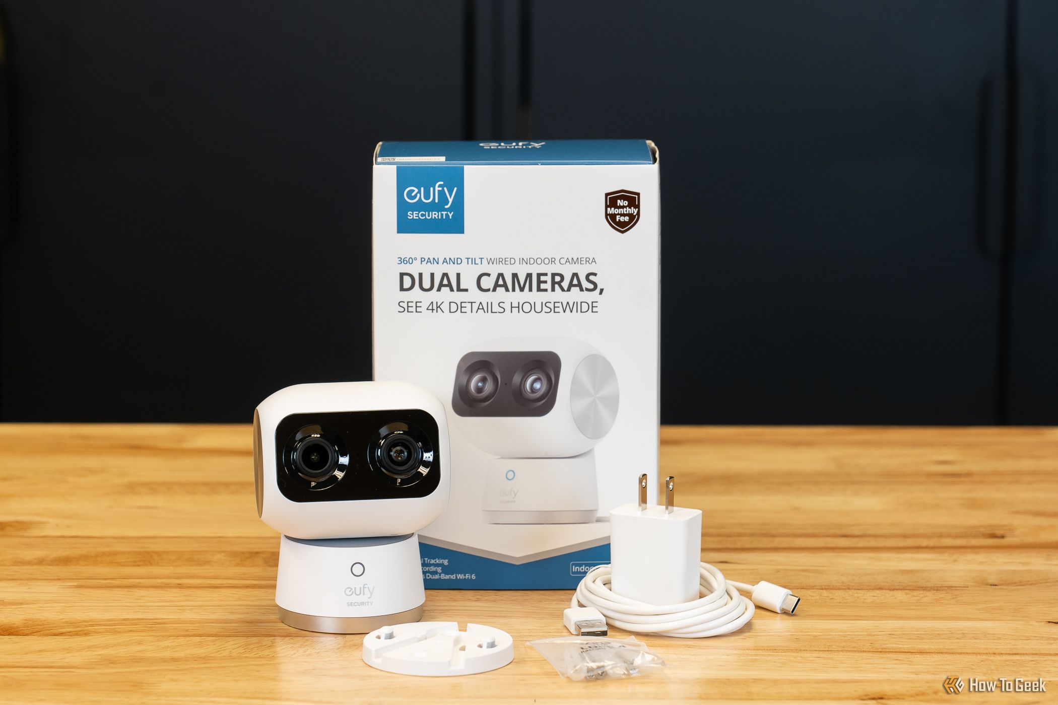 The The Eufy Security Indoor Cam S350 with mounting plate screws and USB-C cable in front of box