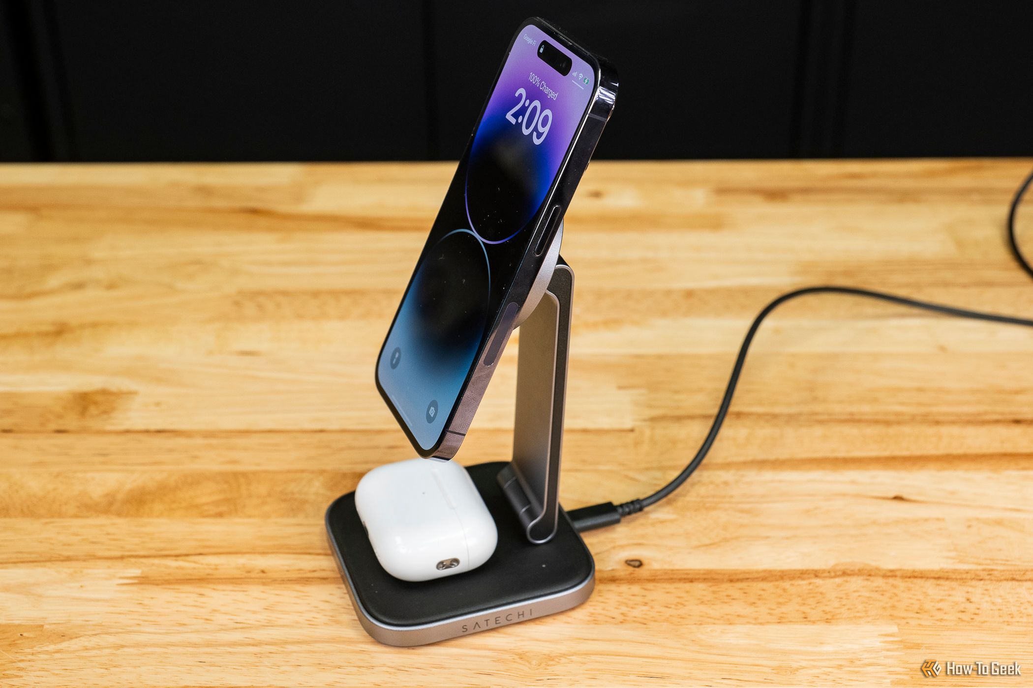 Satechi 2-in-1 Foldable Qi2 Wireless Charging Stand charging an iPhone and Airpods from the side