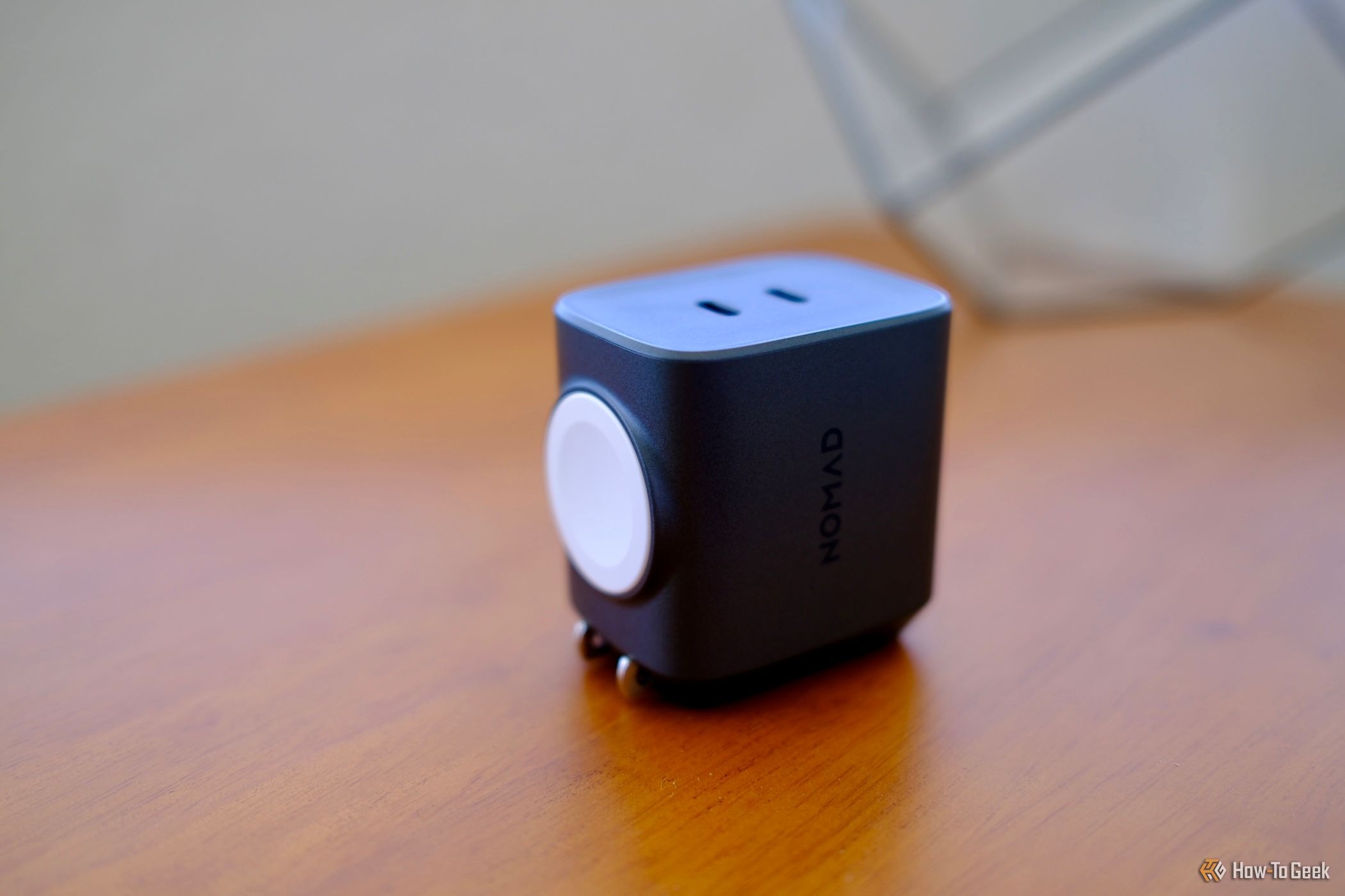 Nomad 65W Power Adapter Watch Edition laying on a table
