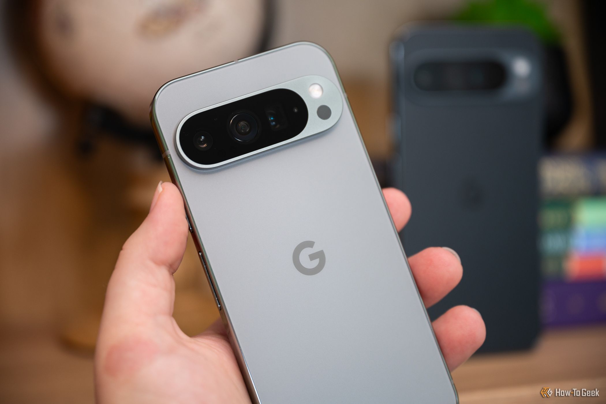 Person holding the Google Pixel 9 Pro in front of the 9 Pro XL-1