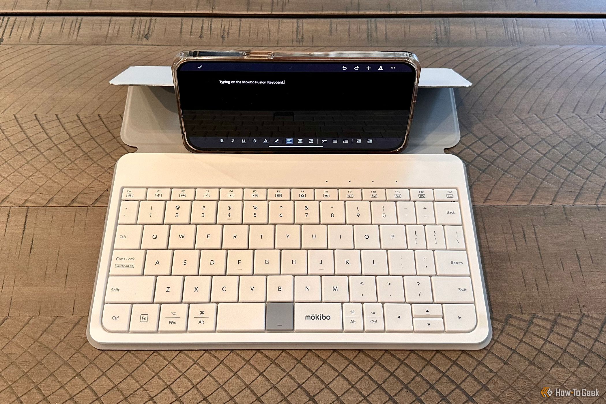 Mokibo Fusion Keyboard holding an Apple iPhone 14 Pro Max in landscape