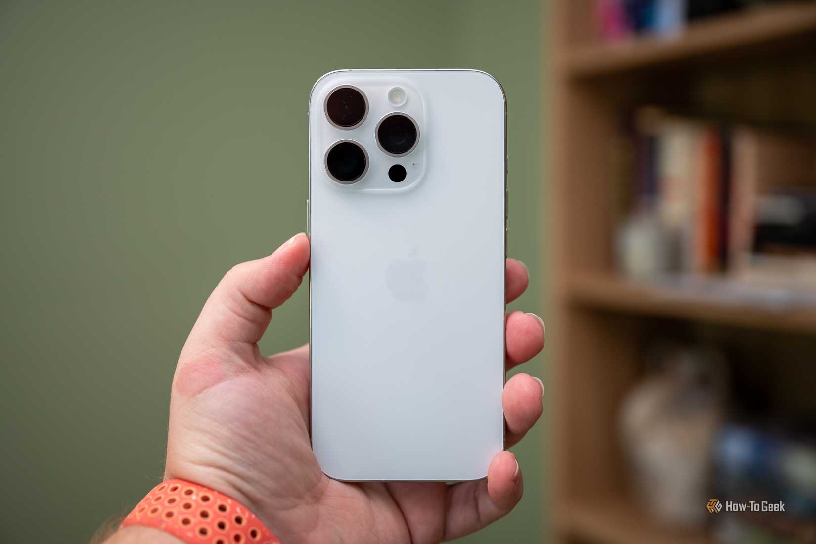 Человек держит iPhone 16 Pro.