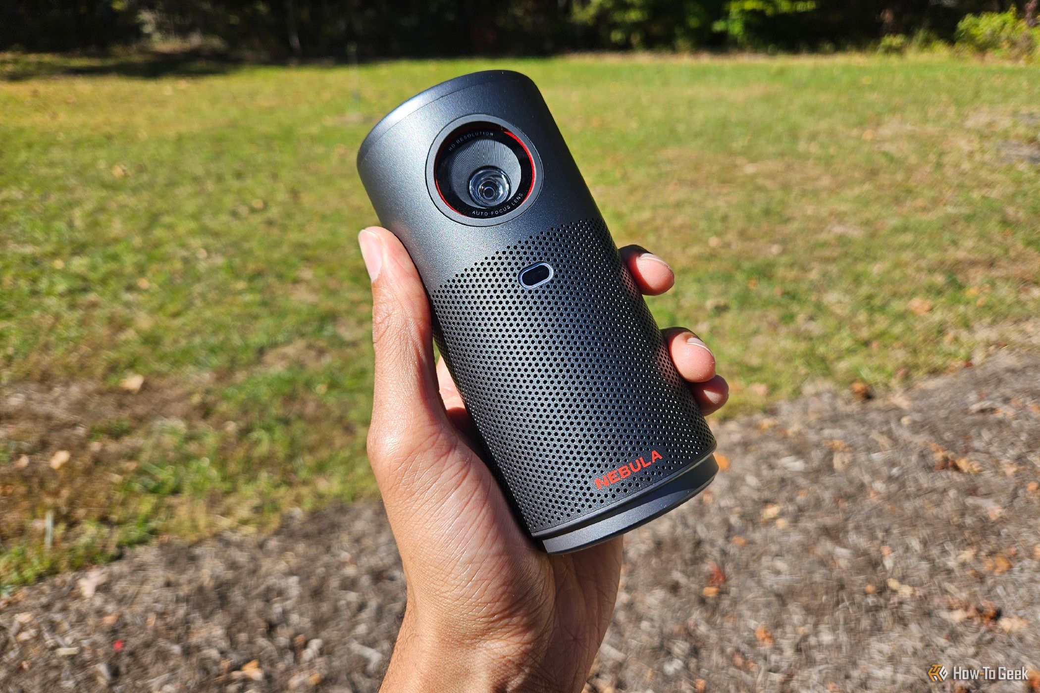 Hand holding a Nebula Capsule Air projector outdoors