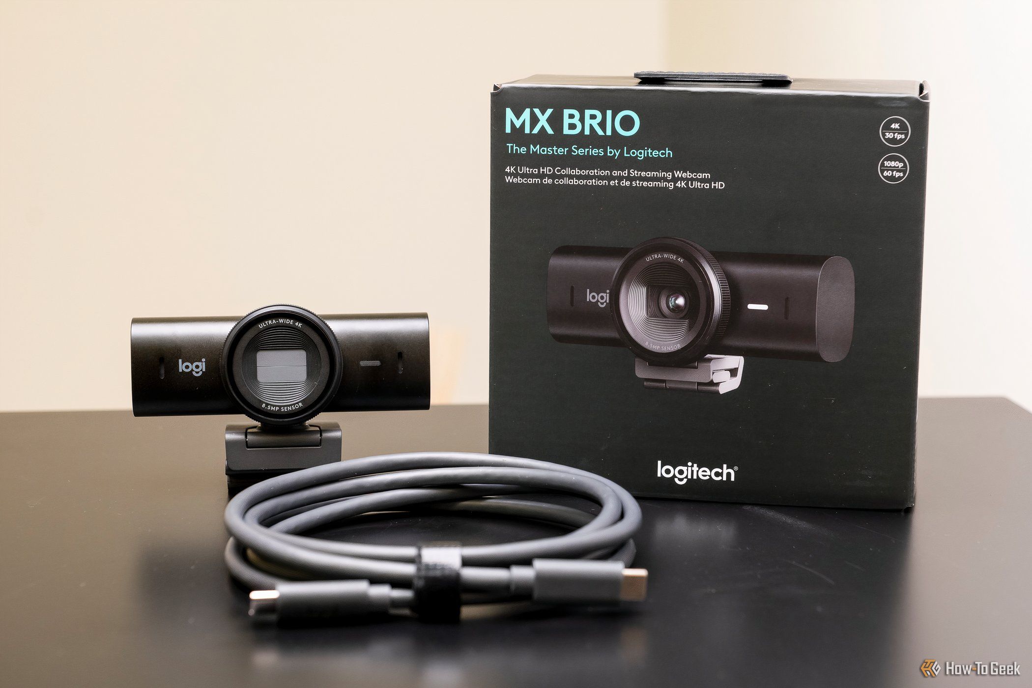 The Logitech MX Brio shown with USB cable and box