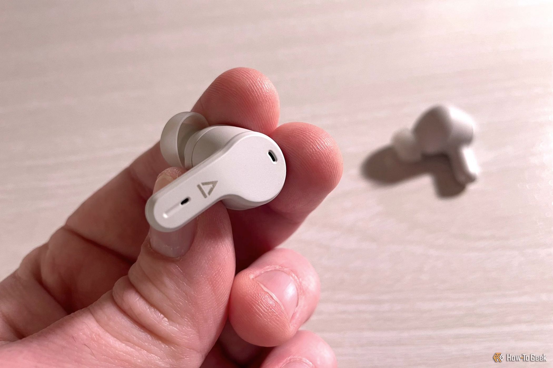 A hand holding the Creative Zen Air SXFI earbuds.