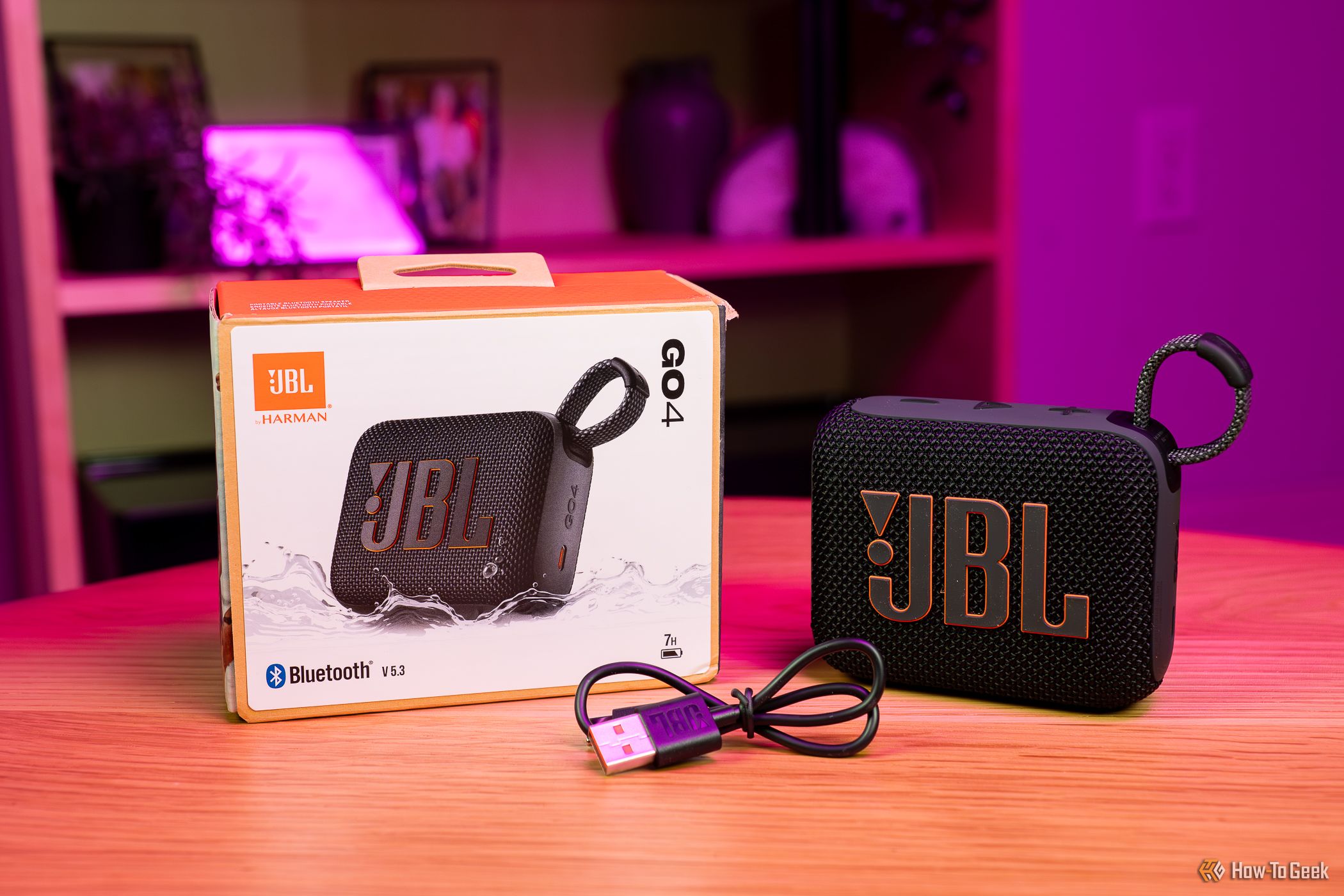 The JBL Go 4 next to cable and box.