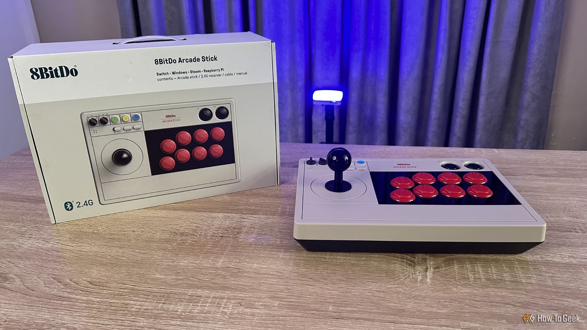 The 8BitDo Arcade Stick for Switch next to its retail box.