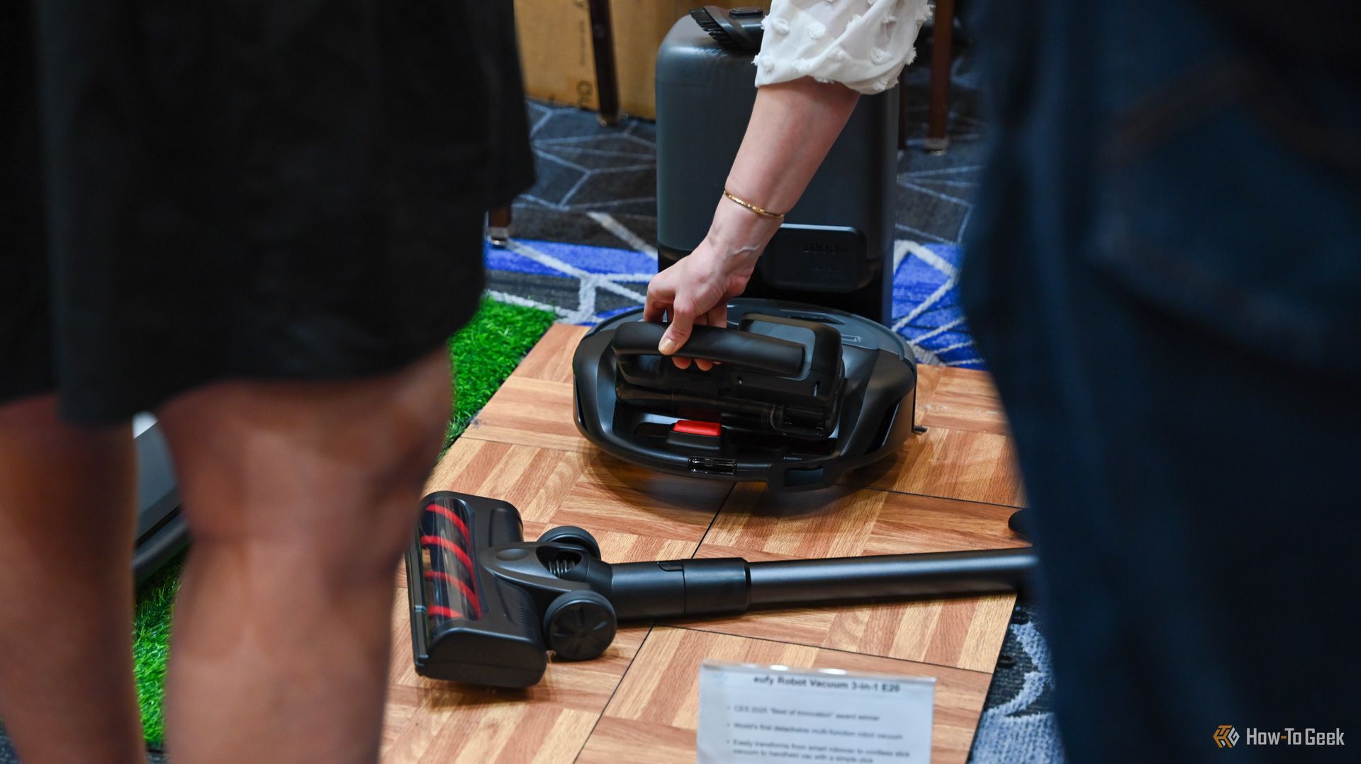 Person removing the handheld section of the Eufy Clean E20 3-in-1 Robot Vacuum at CES 2025.