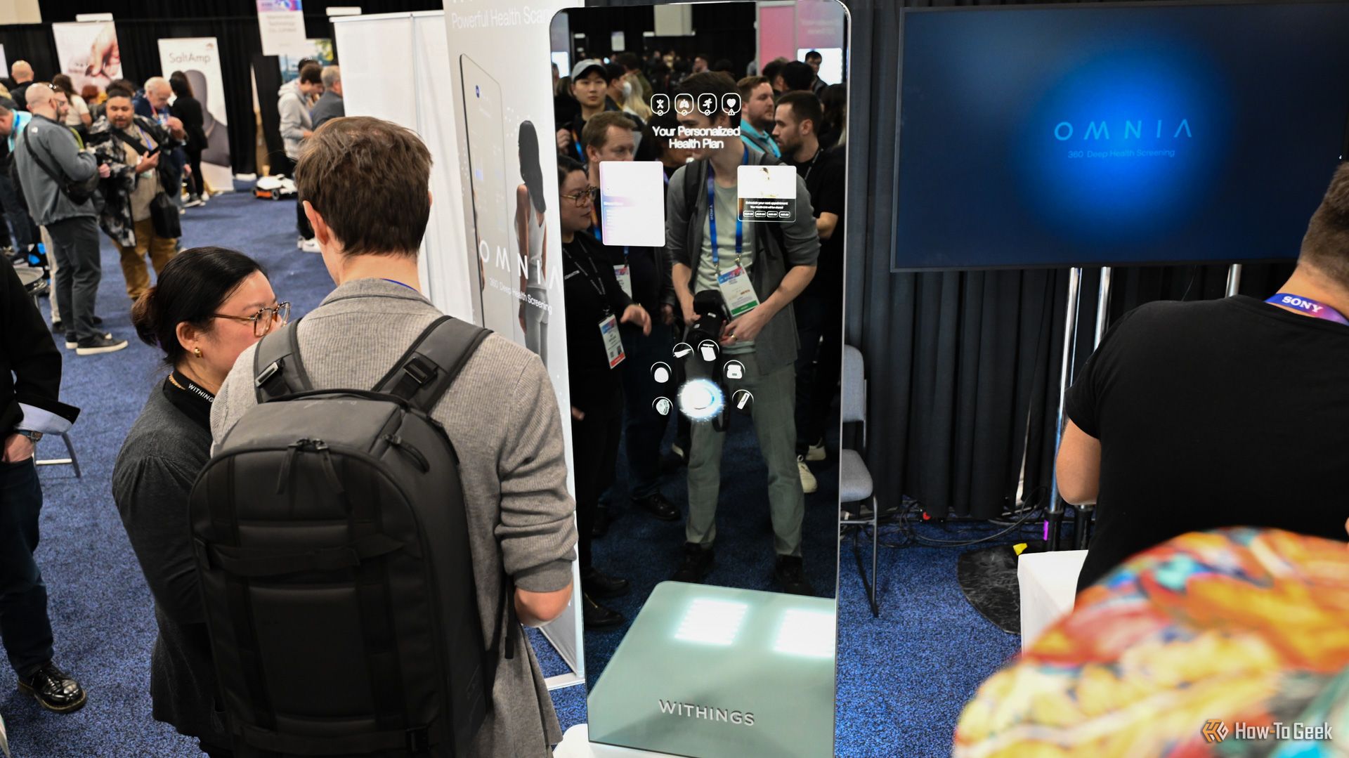 People looking at the Withings OMNIA Health Screening Mirror concept at CES.