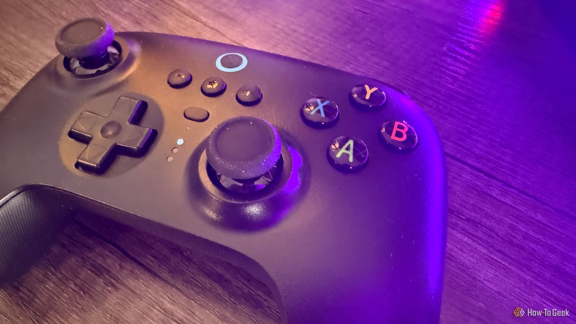 8BitDo Ultimate 2.4G Controller on a table with purple lighting.