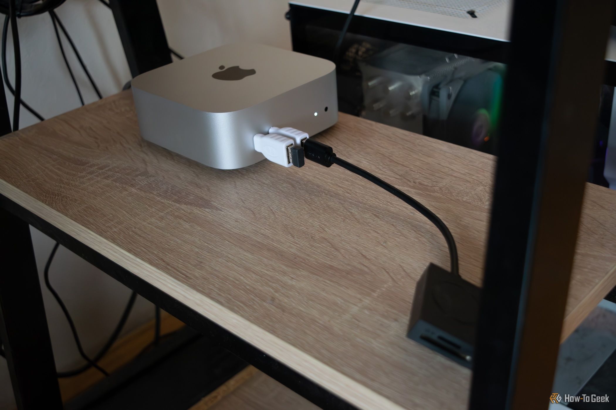 An Apple M4 Mac Mini sitting under a table. 