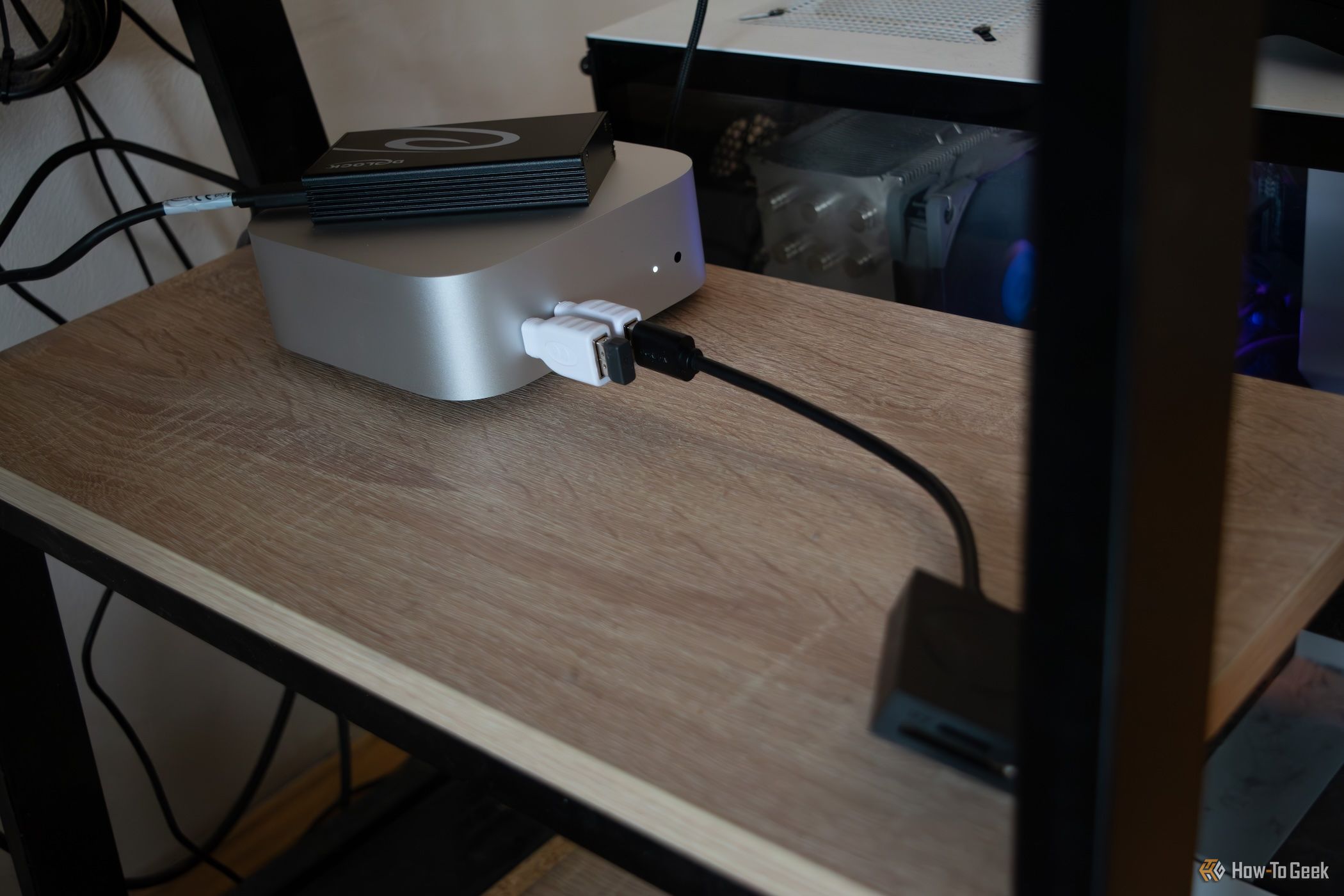 An Apple M4 Mac Mini sitting under a desk with an external SSD connected to it. 