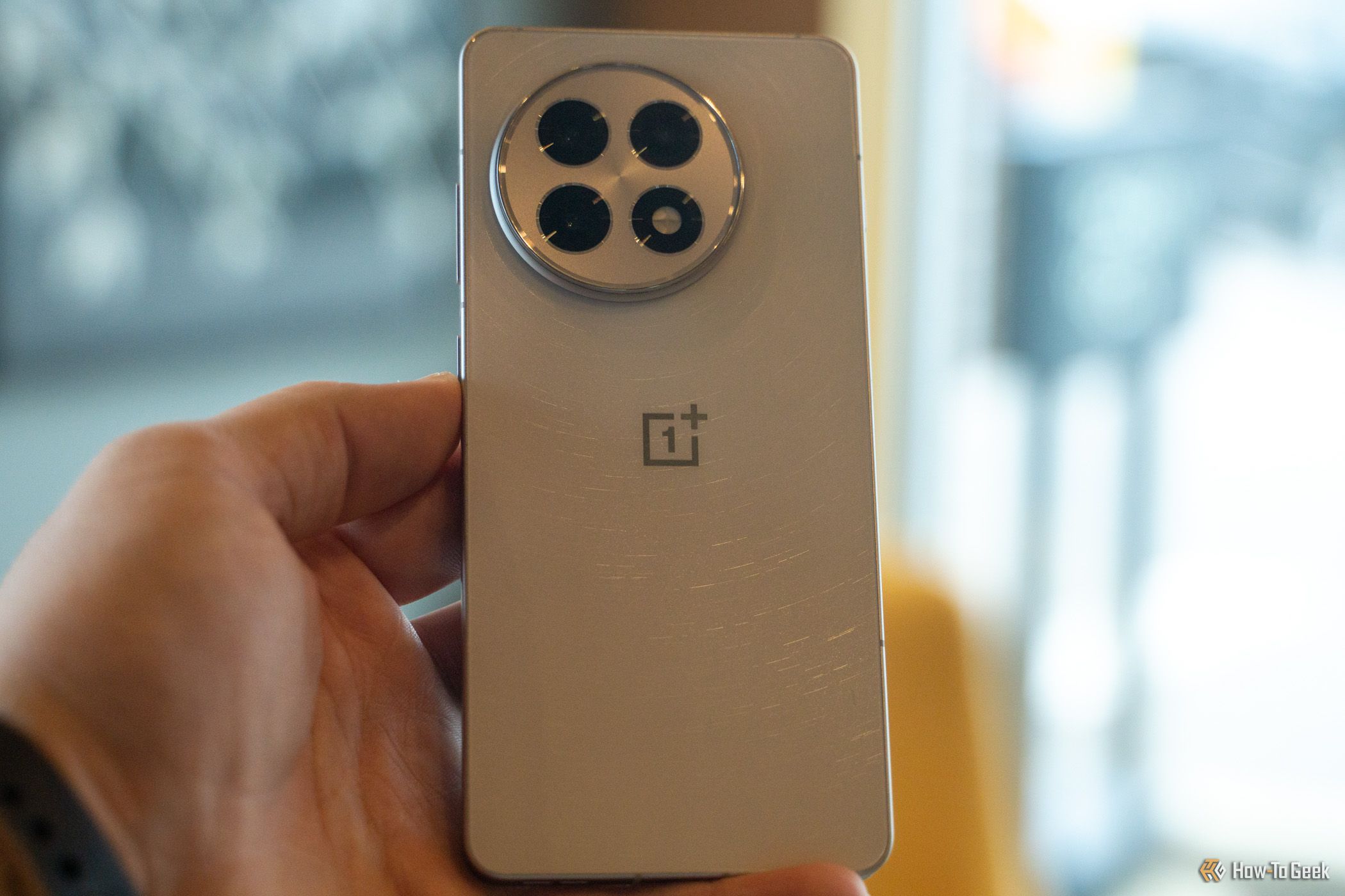 The back of the OnePlus 13R being held in a hand.