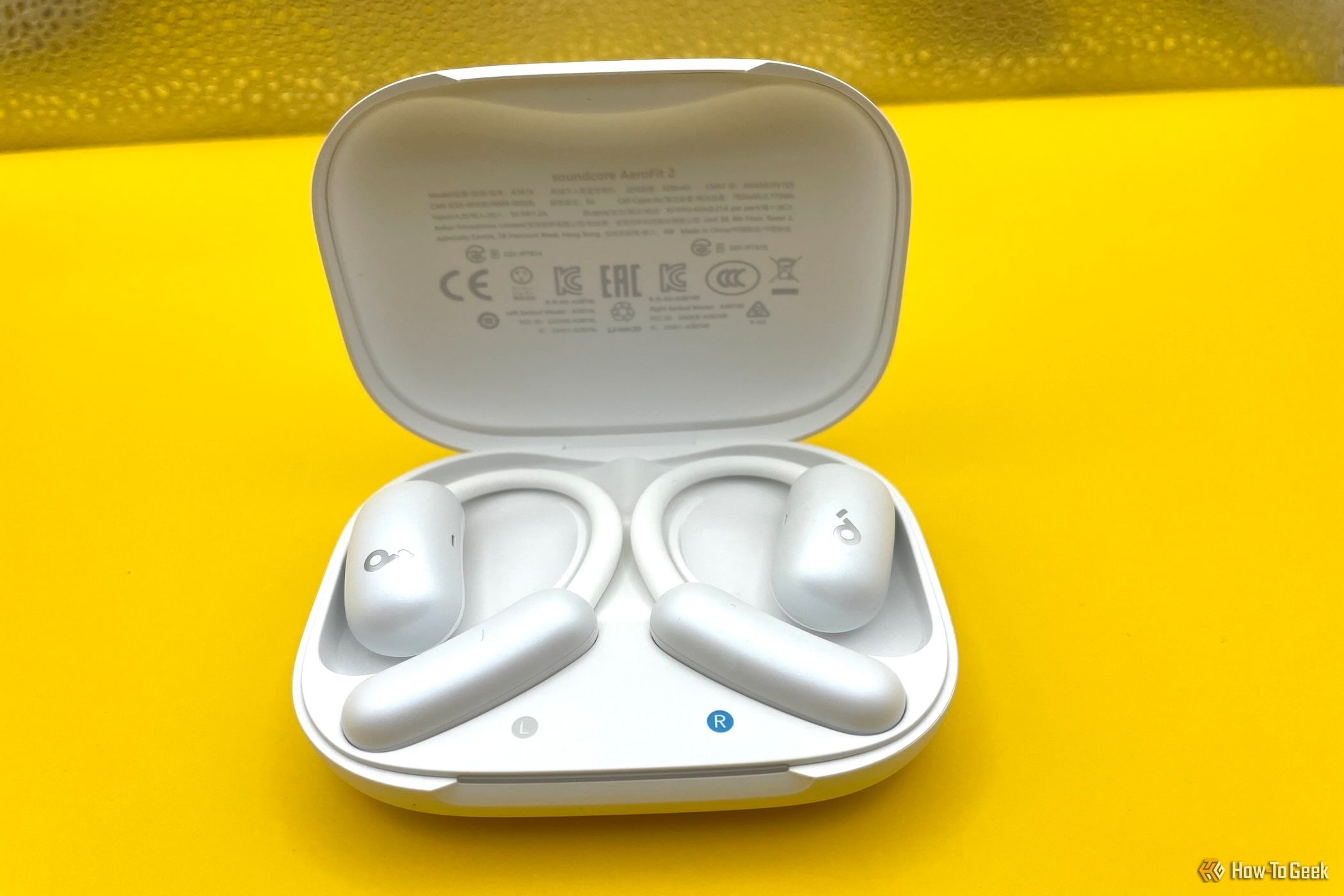 The Soundcore AeroFit 2 earbuds in their charging case.