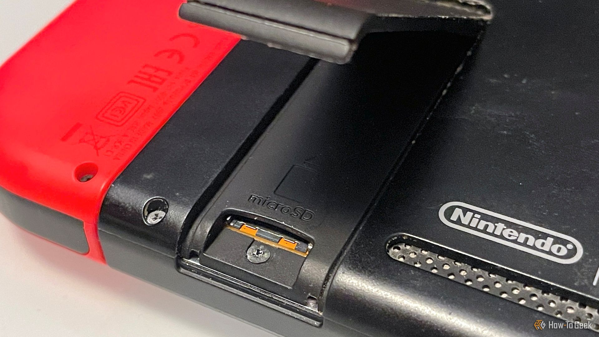 Open microSD card door on the back of a Switch console.