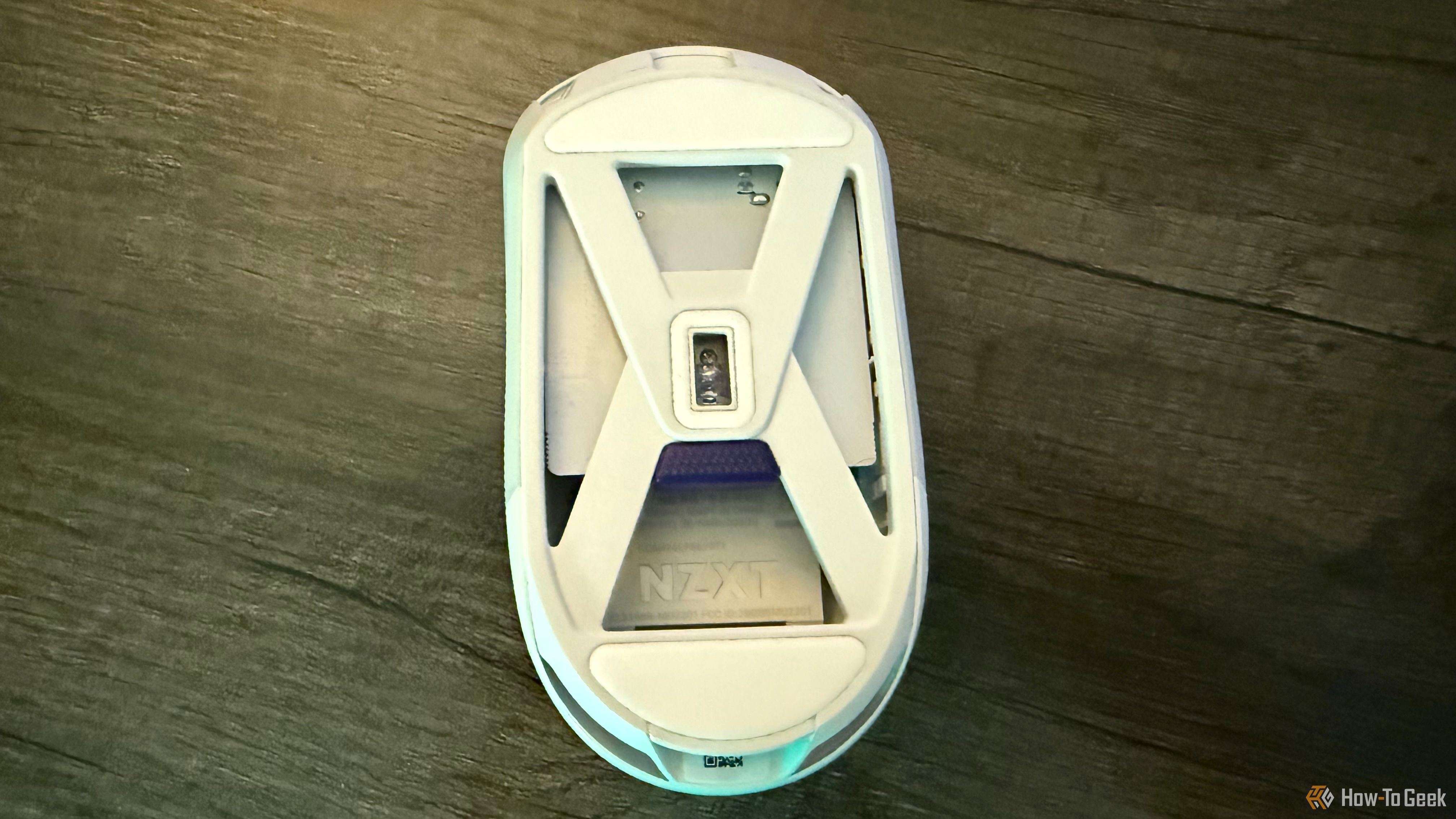 The bottom of the NZXT Lift Elite Wireless mouse on a table.