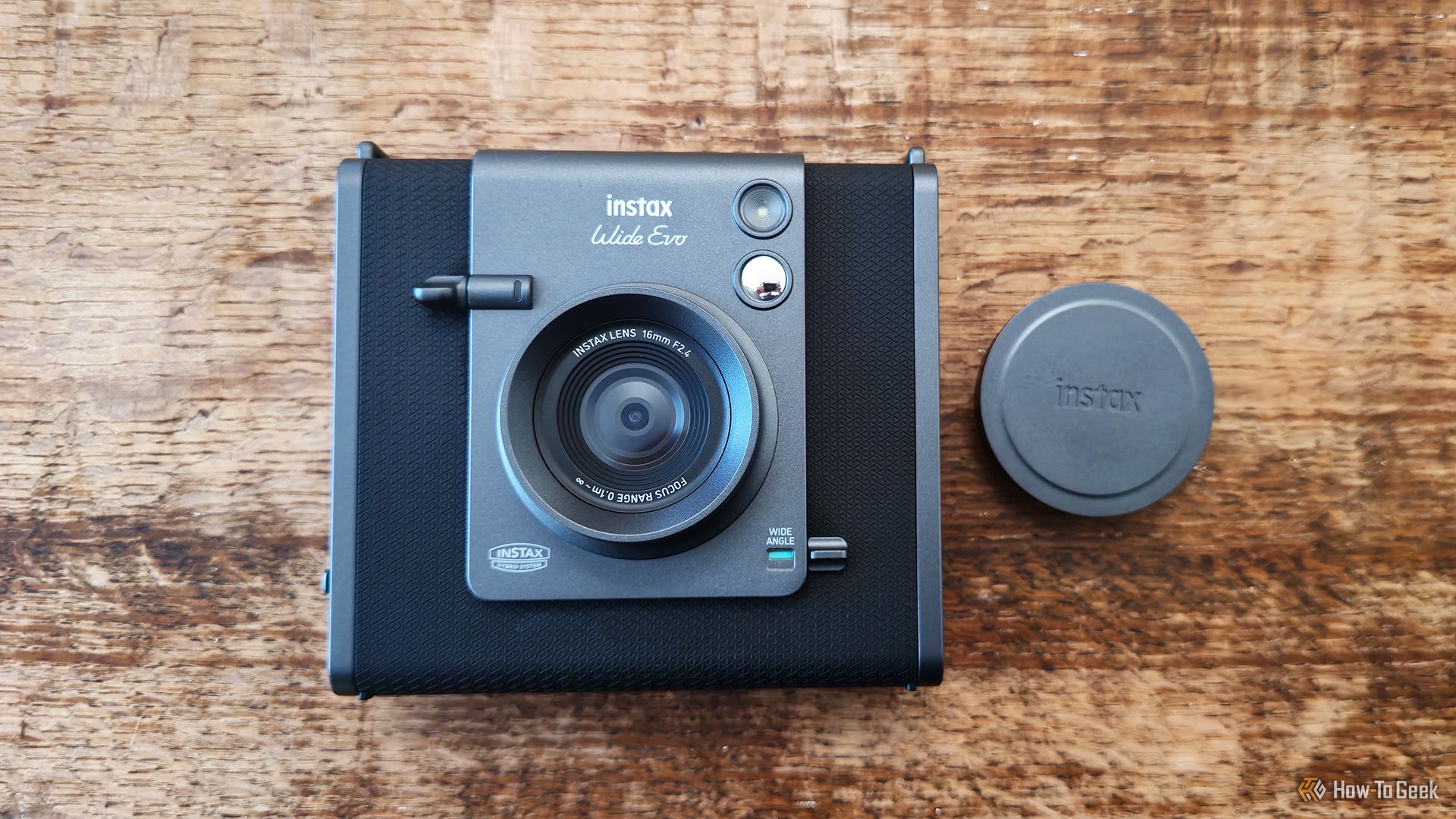 The Instax Wide Evo hybid camera with the lens cap off.