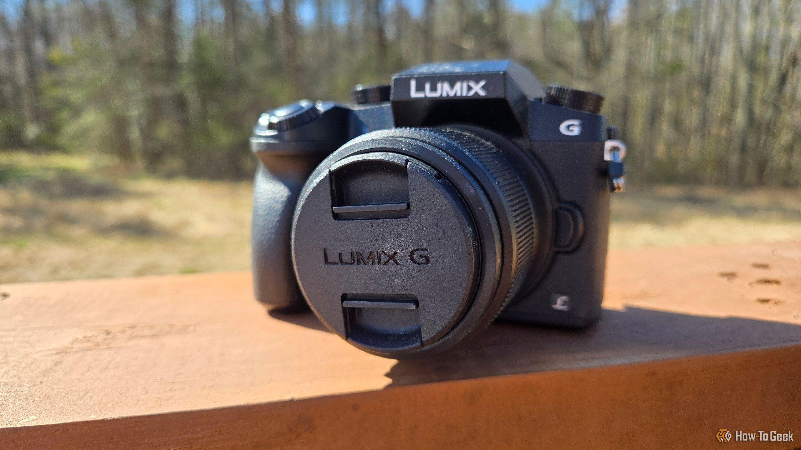 A Panasonic Lumix G7 on the railing of a deck.