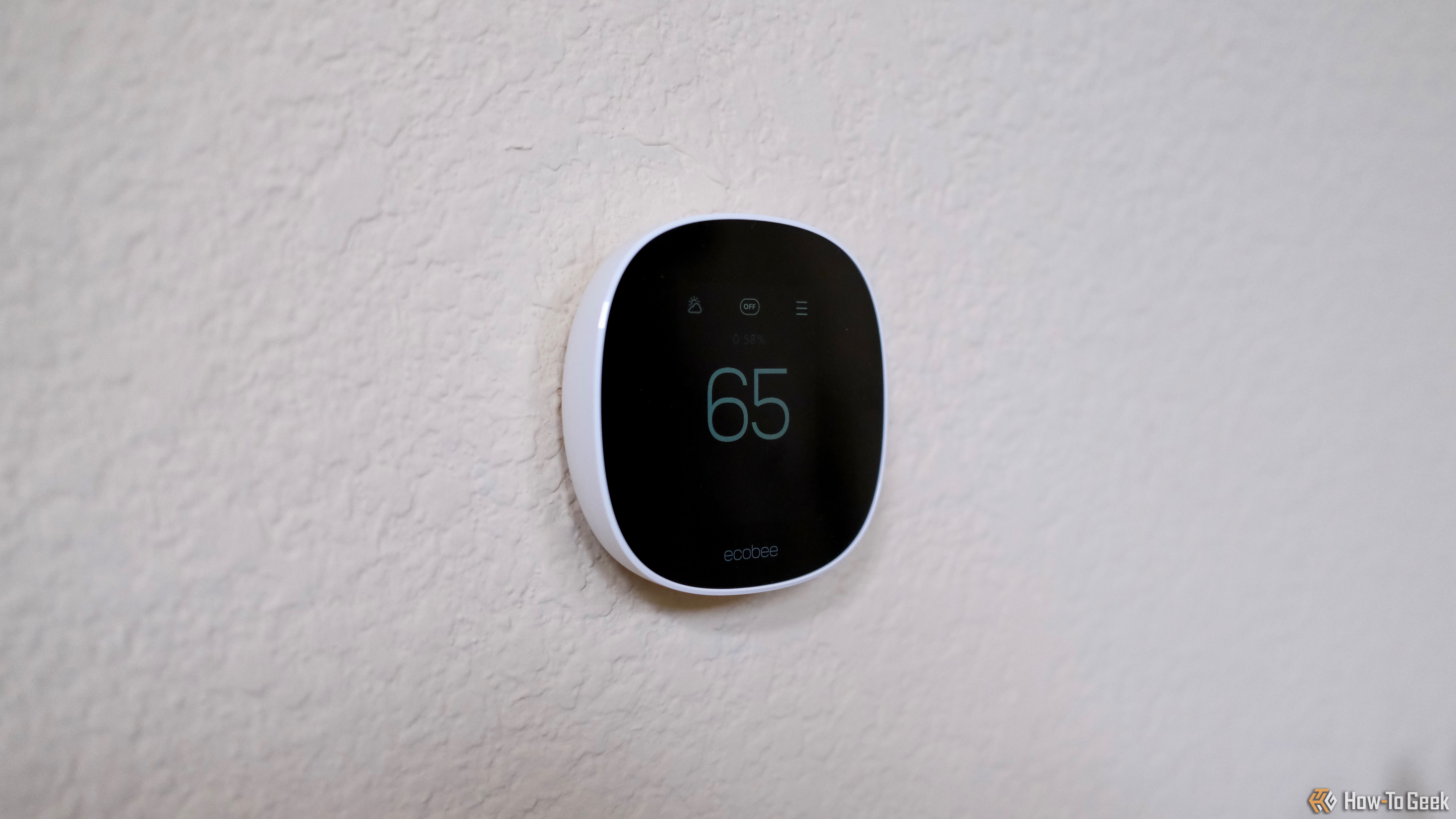 Ecobee Smart Thermostat Essential dimmed showing 65 degrees.