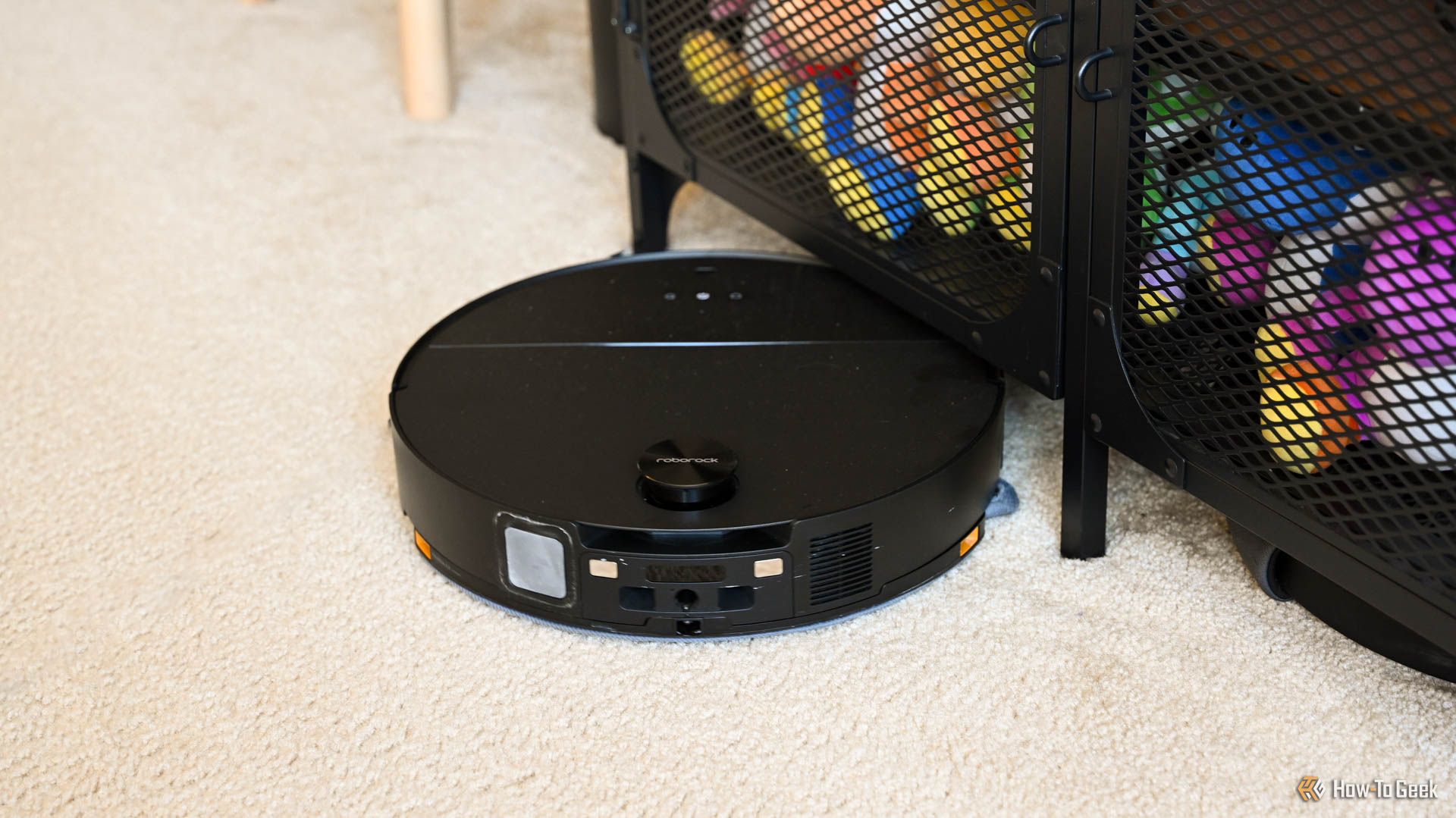 Roborock Saros 10 cleaning near an entertainment center.