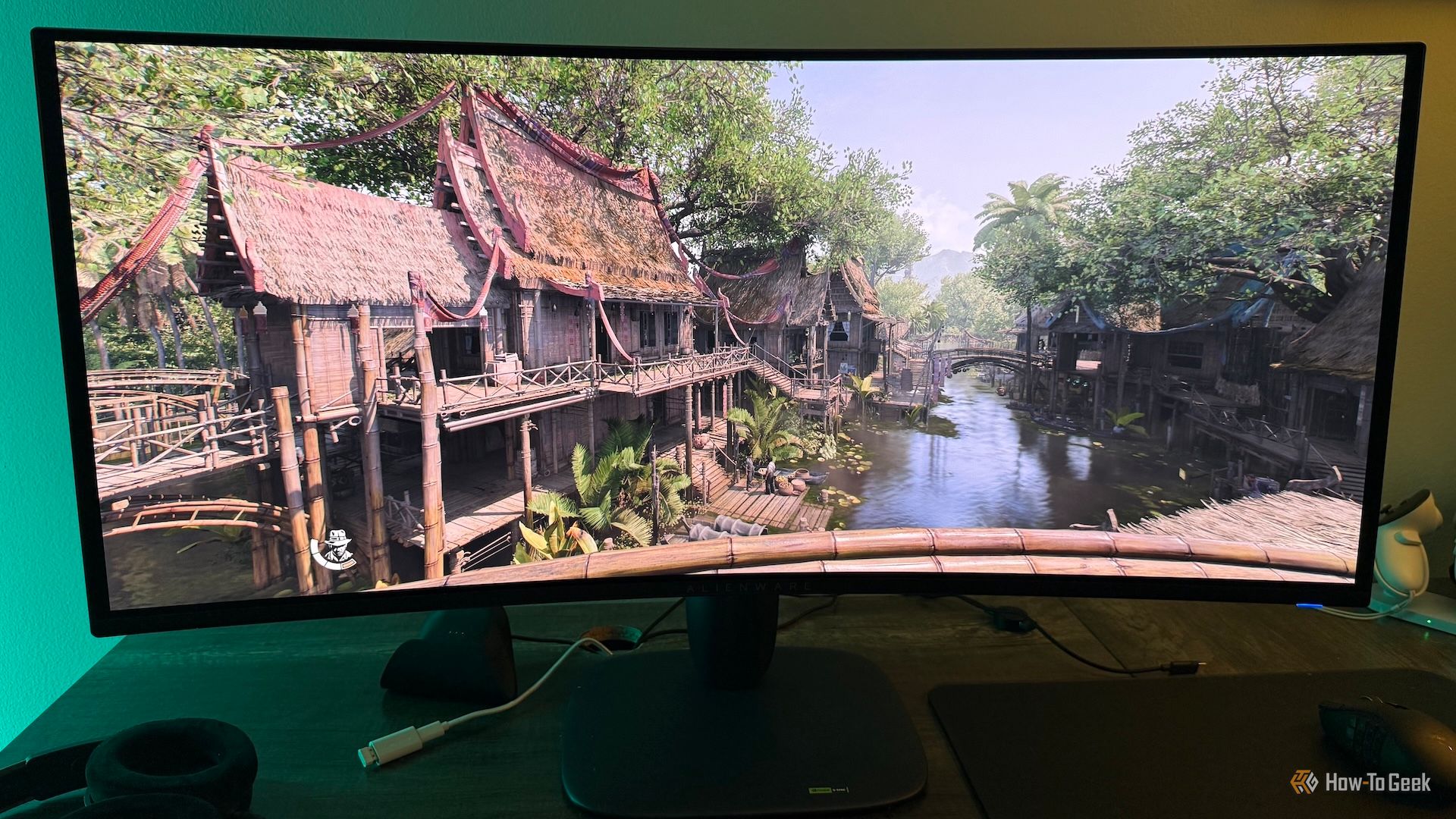 An Alienware AW3425DW curved ultrawide gaming monitor with a town in Siam from Indiana Jones and the Great Circle on it in HDR.
