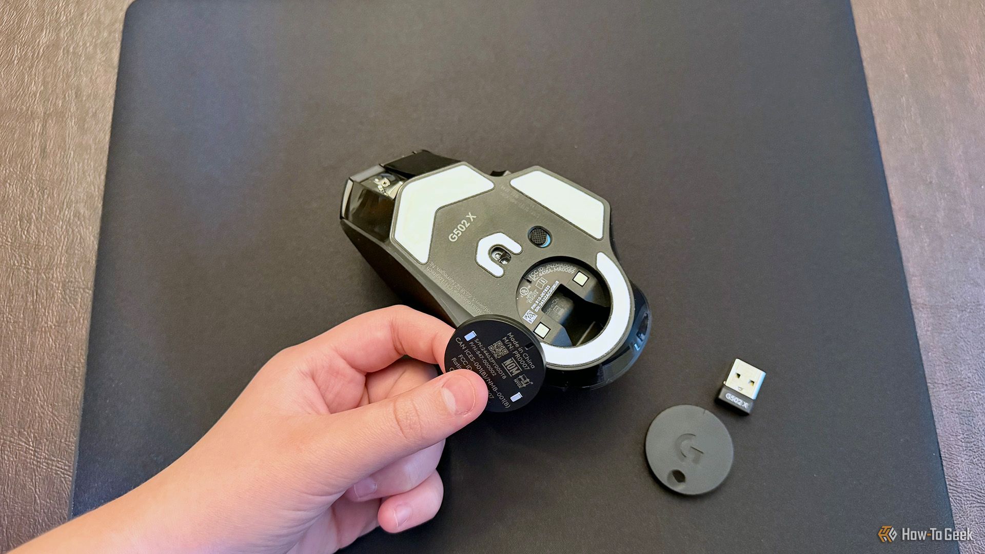 Inserting the Powerplay 2 coin in a Logitech G502 X Plus Lightspeed mouse.