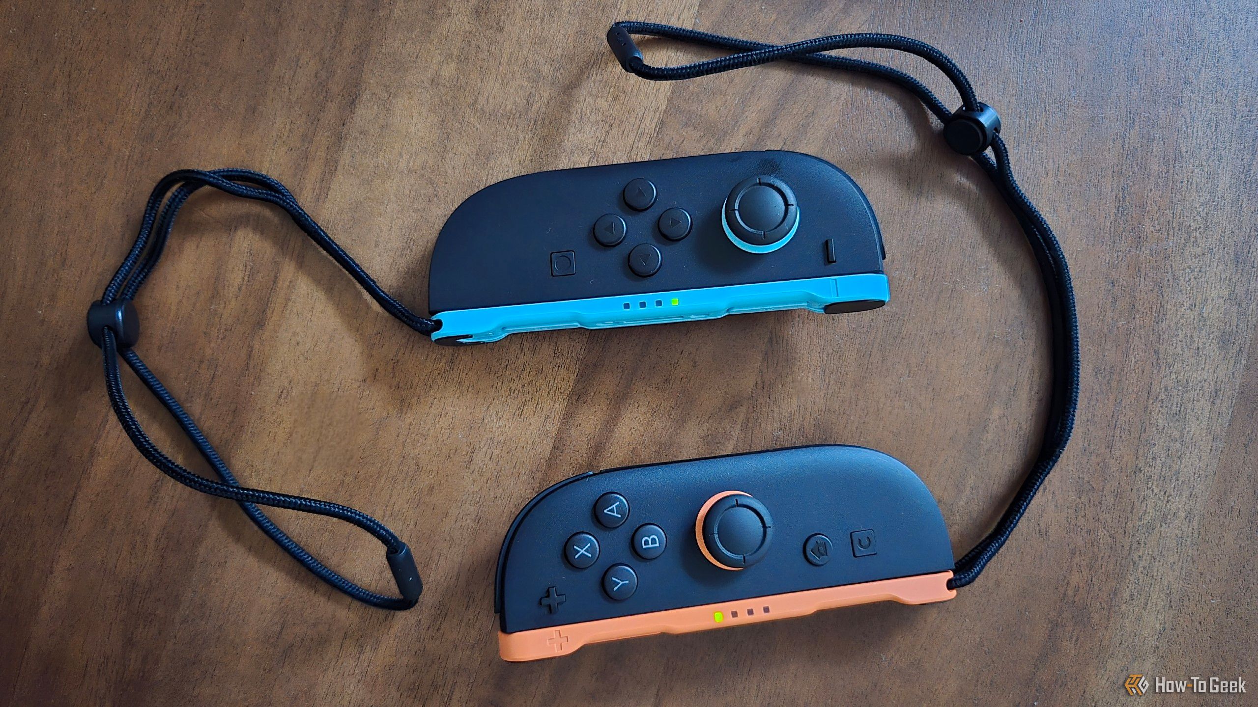 A pair of Joy-Con 2 on a table, with included wrist straps.