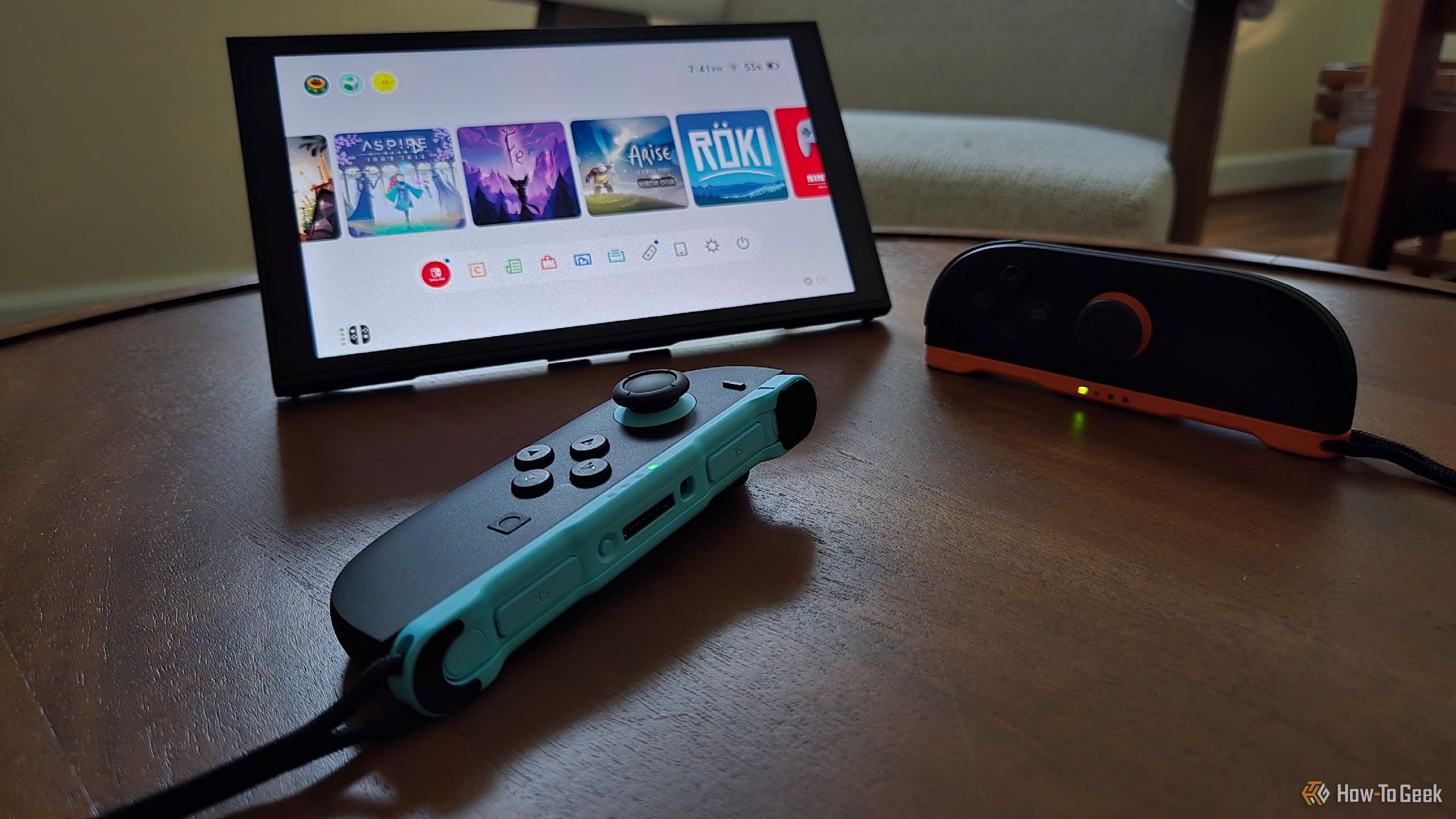 A pair of Joy-Cons 2 in front of a Switch 2 upright using its built-in stand, with one being used as a mouse.