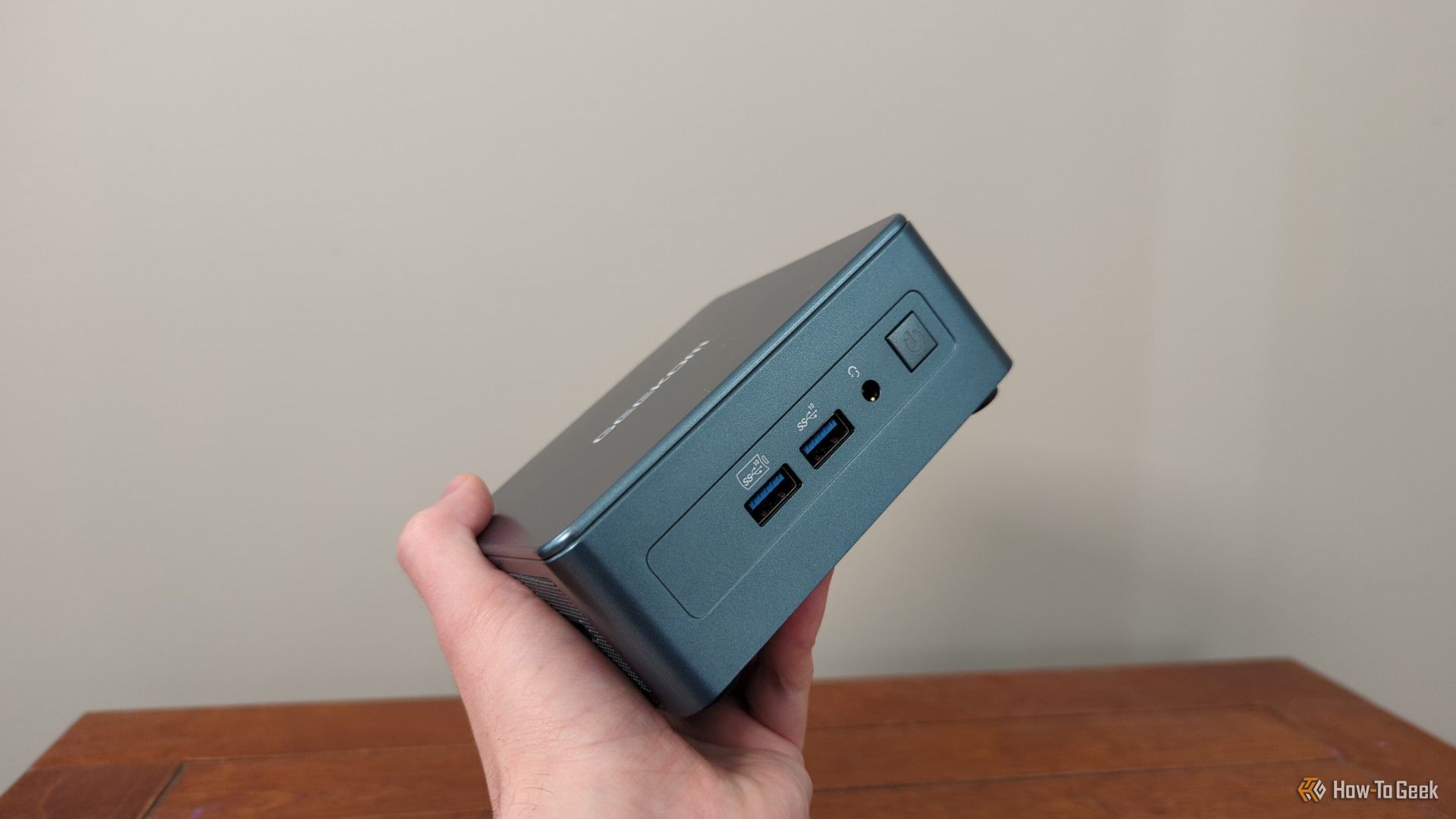 A person holding a geekom mini pc.-1