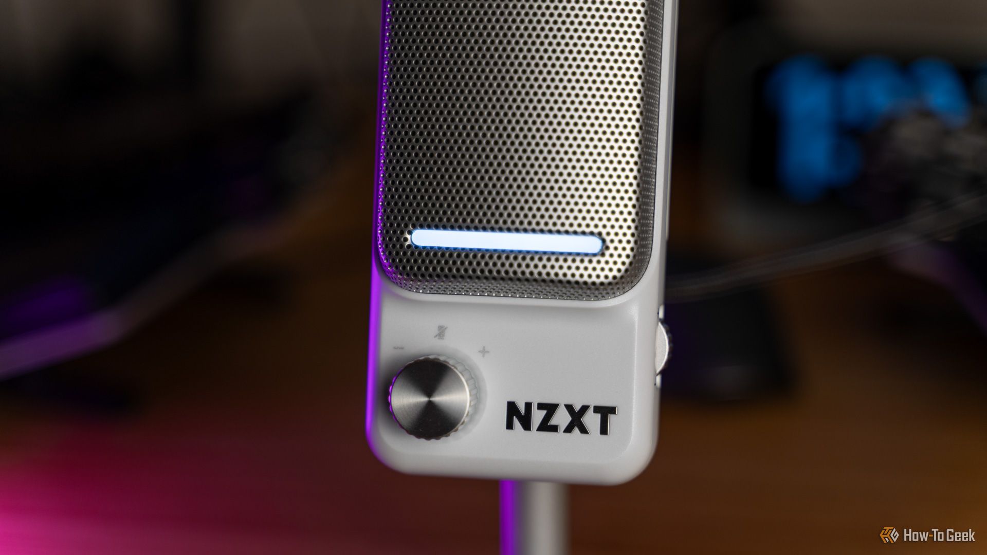 The front of the NZXT Capsule Elite microphone showing the gain knob, light bar, and logo.