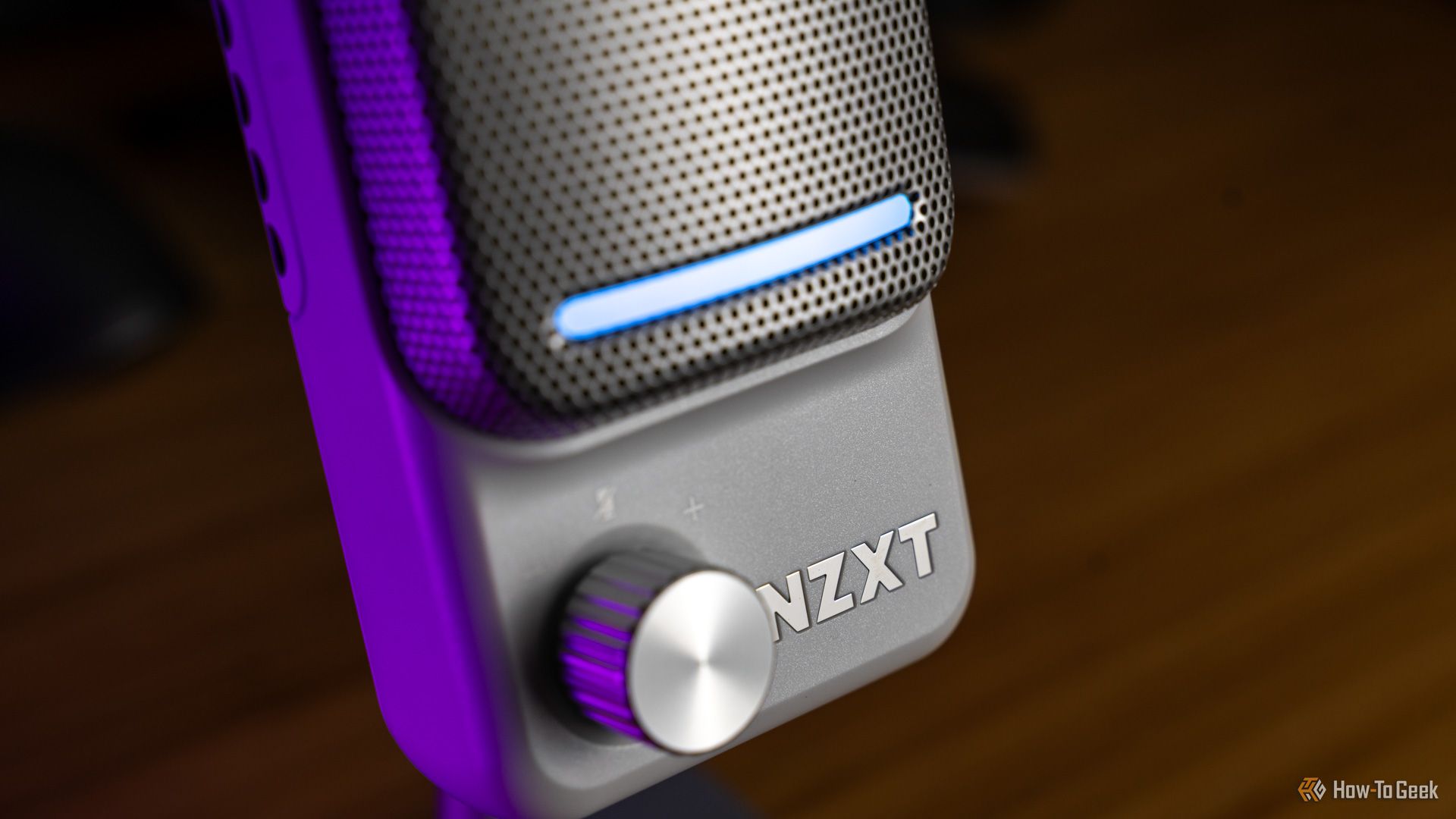 A side shot of the NZXT Capsule Elite microphone showing the gain knob, light bar, and logo.