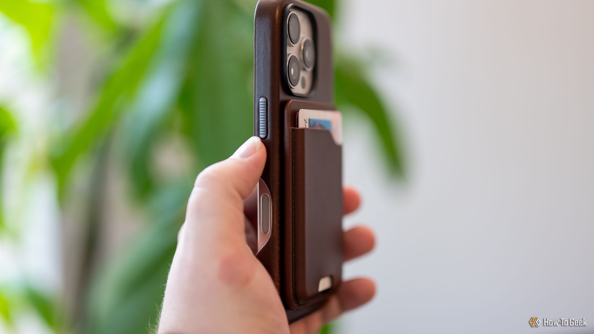 Person holding the Nomad Leather Mag Wallet attached to an iPhone.