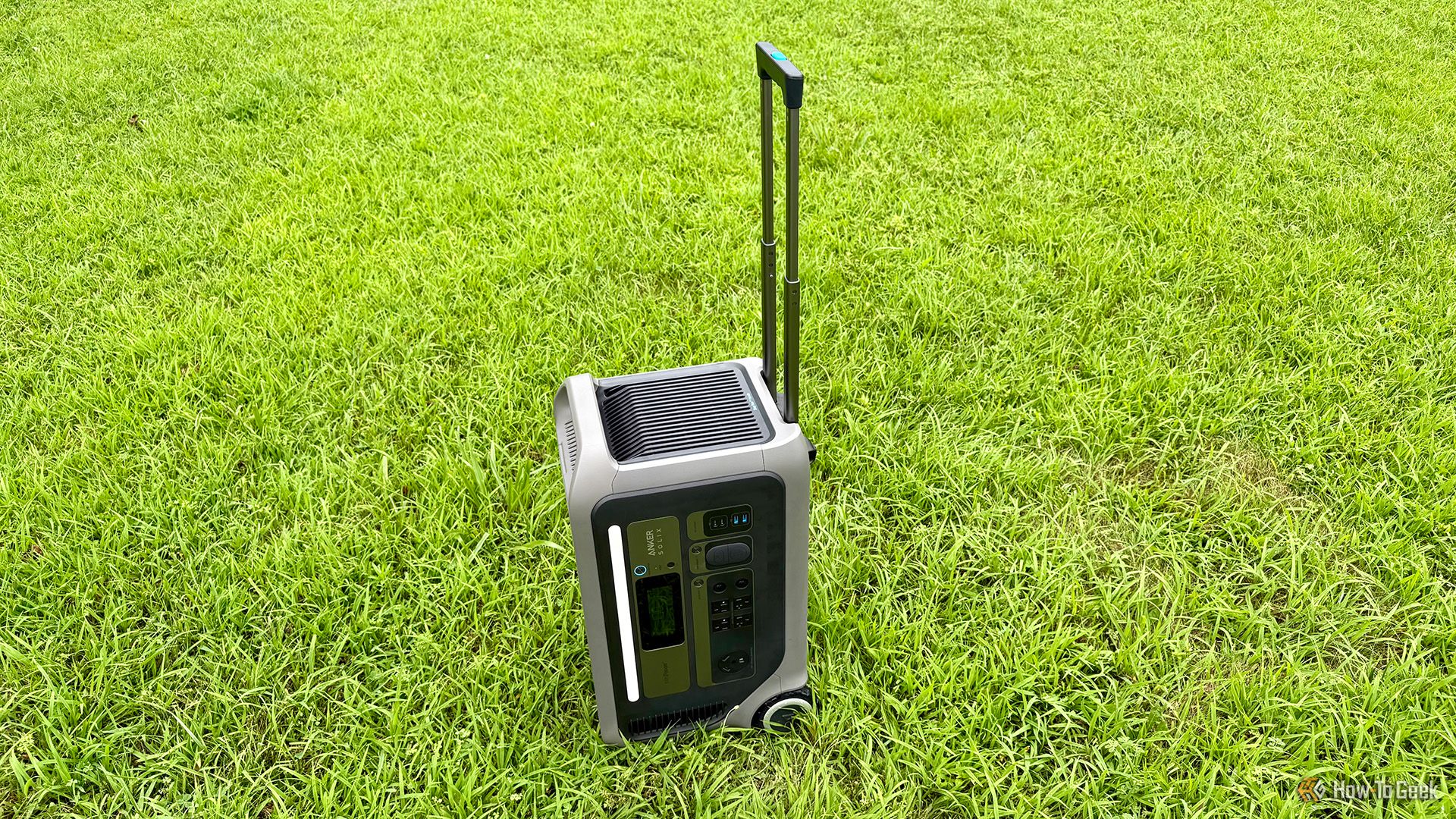 Anker SOLIX F3000 Portable Power Station upright on grass with handle extended.