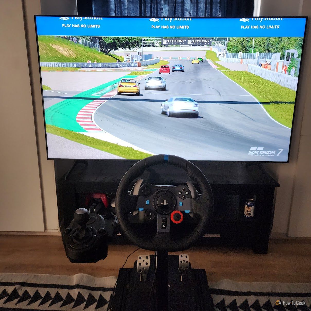 A Logitech G29 racing wheel in front of a large TV.